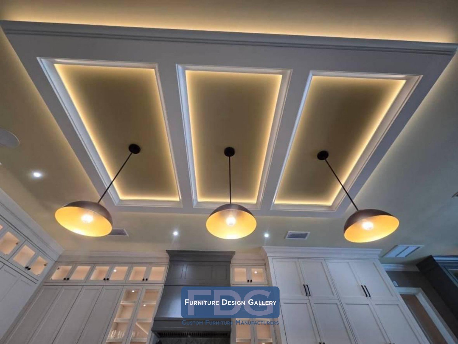 23.  Three-panel coffered ceiling featuring ambient LED cove lighting and matte black pendant fixtures over the island.