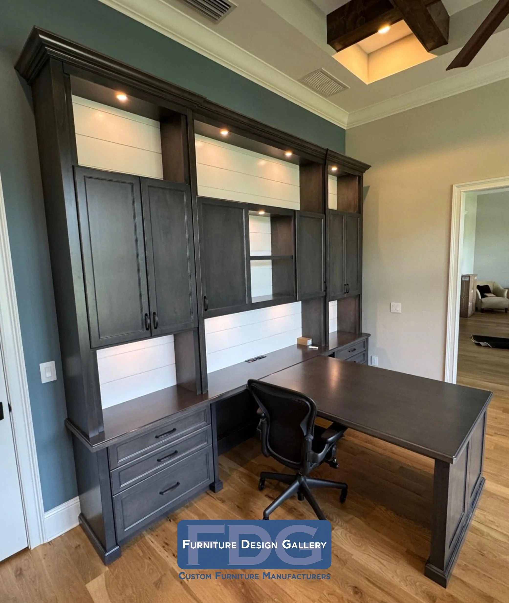 11. Commanding and collaborative. This custom stained partner's desk maximizes productivity with a sprawling T-shaped workspace, integrated shiplap-backed cabinetry, and recessed task lighting for a professional finish.