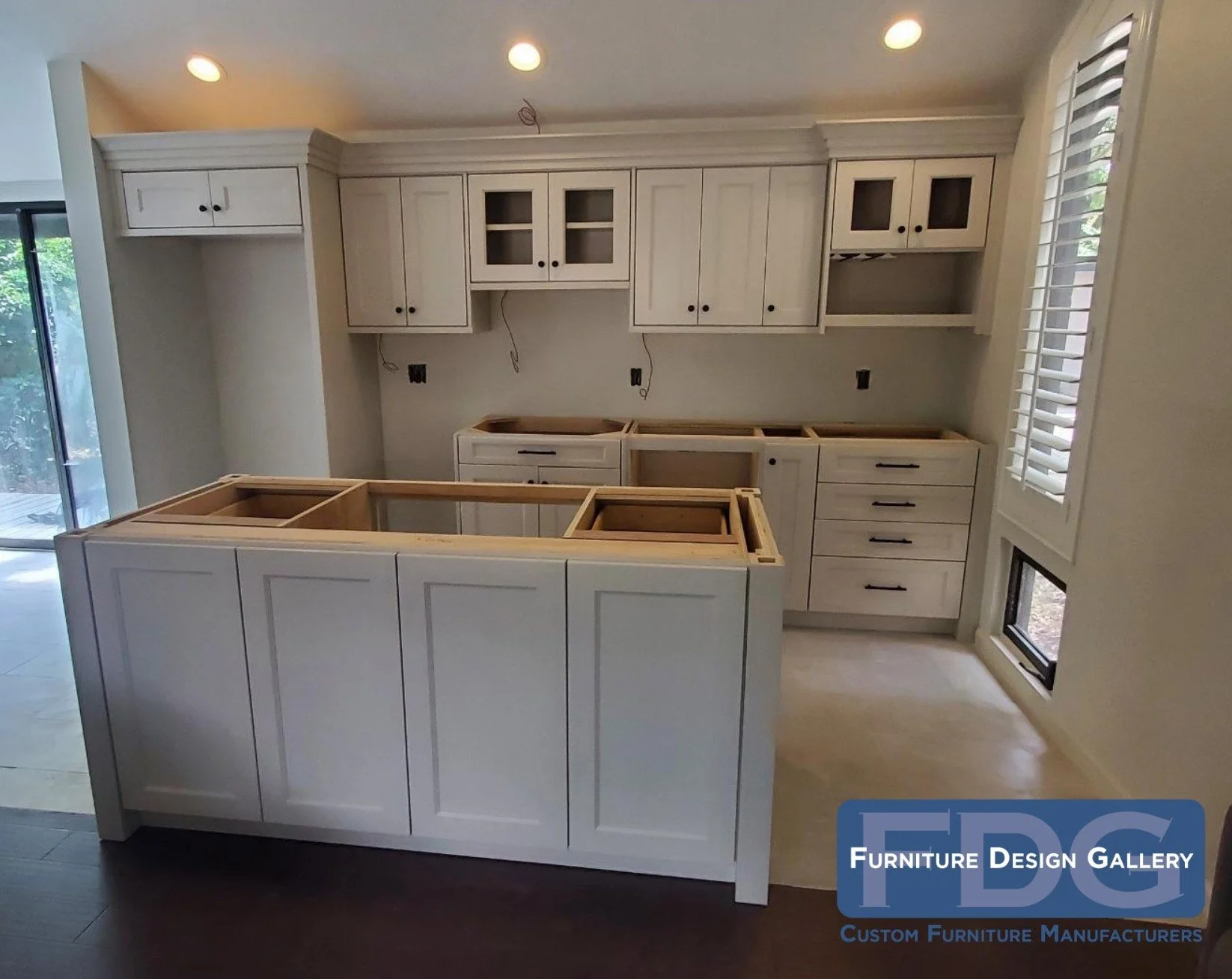 2. Elegant white shaker cabinetry and a custom island-in-progress bring a fresh, timeless look to this bright kitchen remodel.