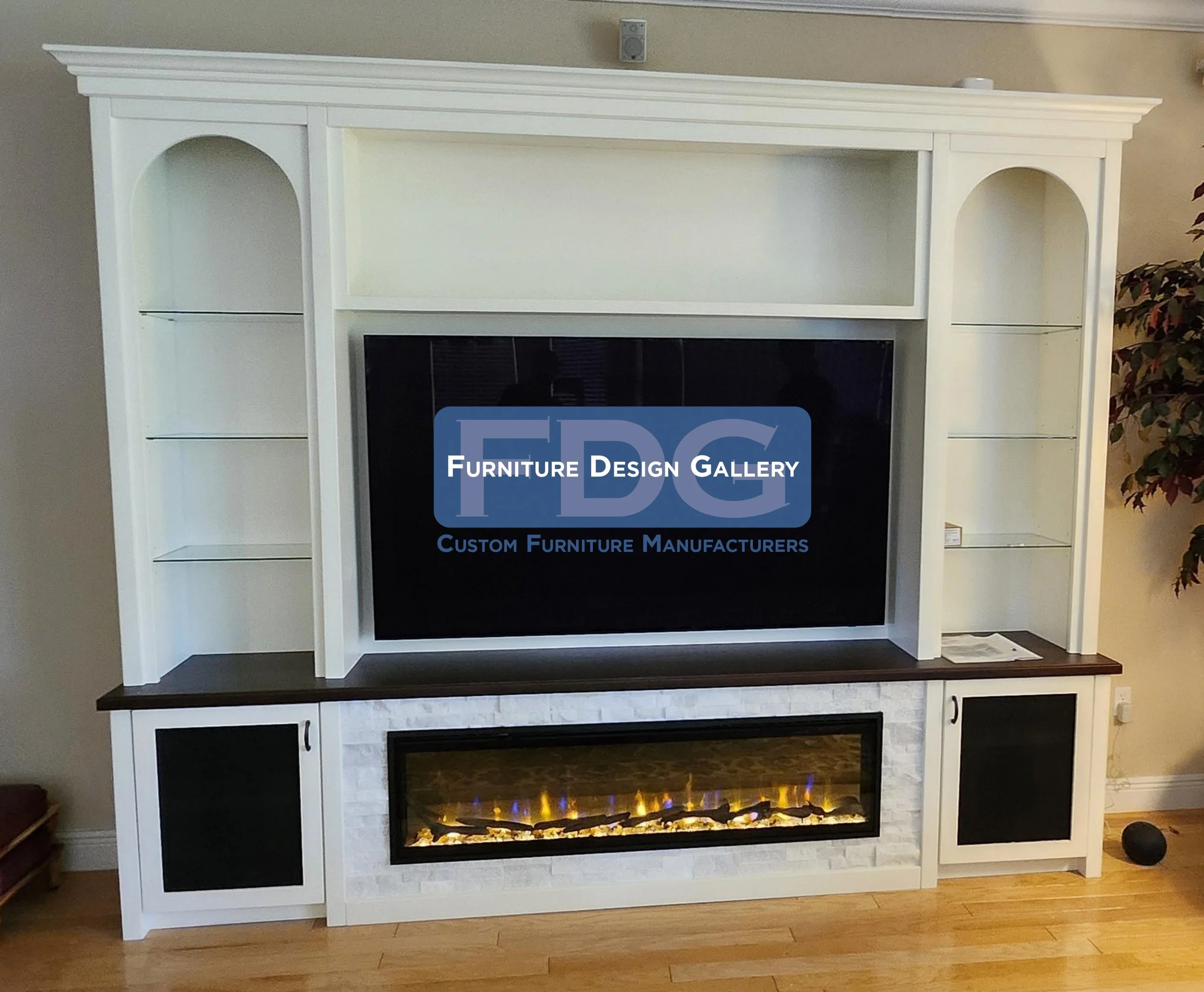 73.  Elevate your living room with a custom entertainment center that perfectly balances traditional style and modern comfort. This bright white unit features elegant arched display shelving, a rich dark wood countertop, a textured stone base, and an