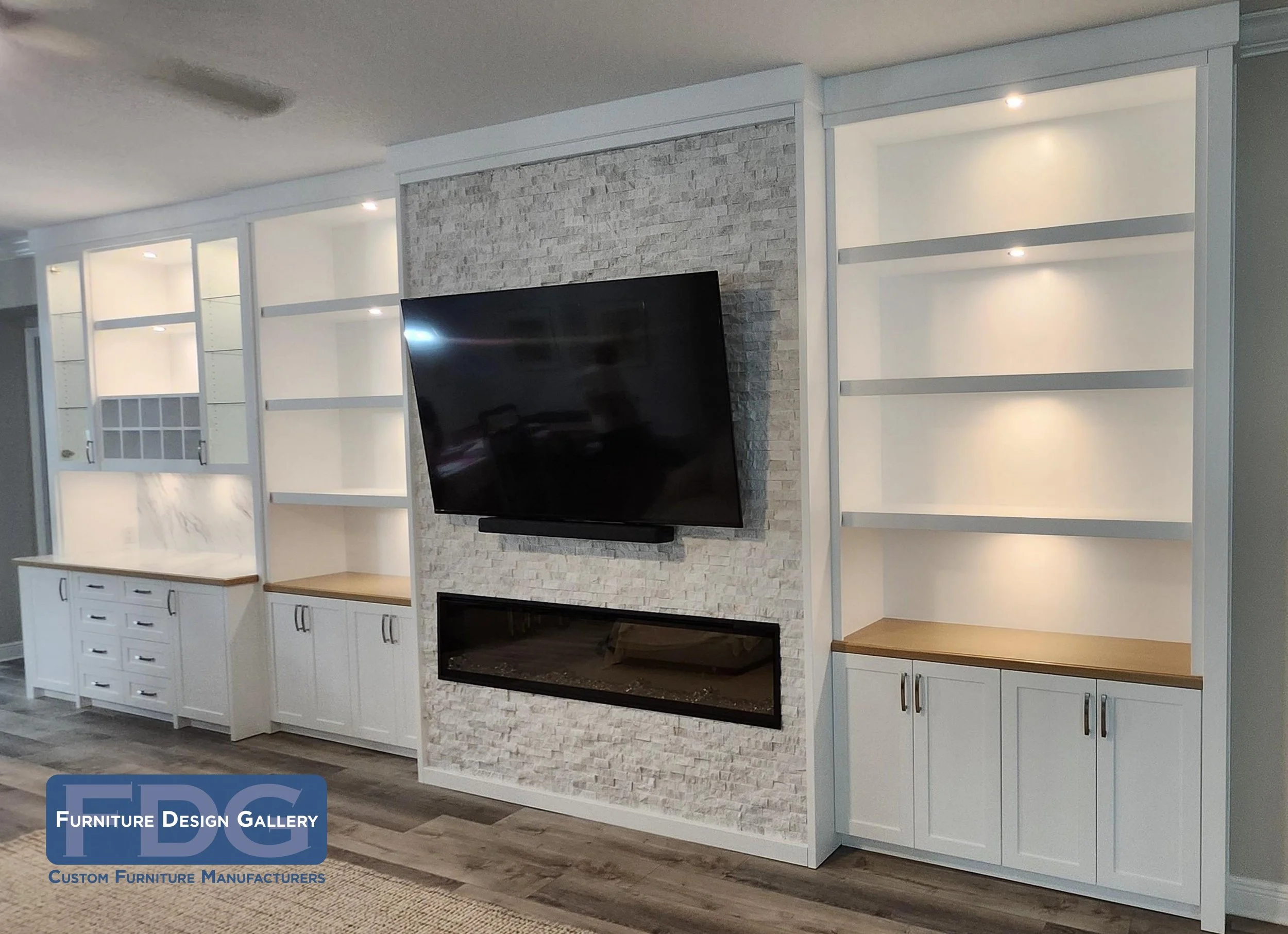 69.  Bring your living room to life with a custom entertainment wall built for hosting. This seamless design pairs a textured stone media center and integrated fireplace with a dedicated home bar, warm LED lighting, and natural wood countertops.