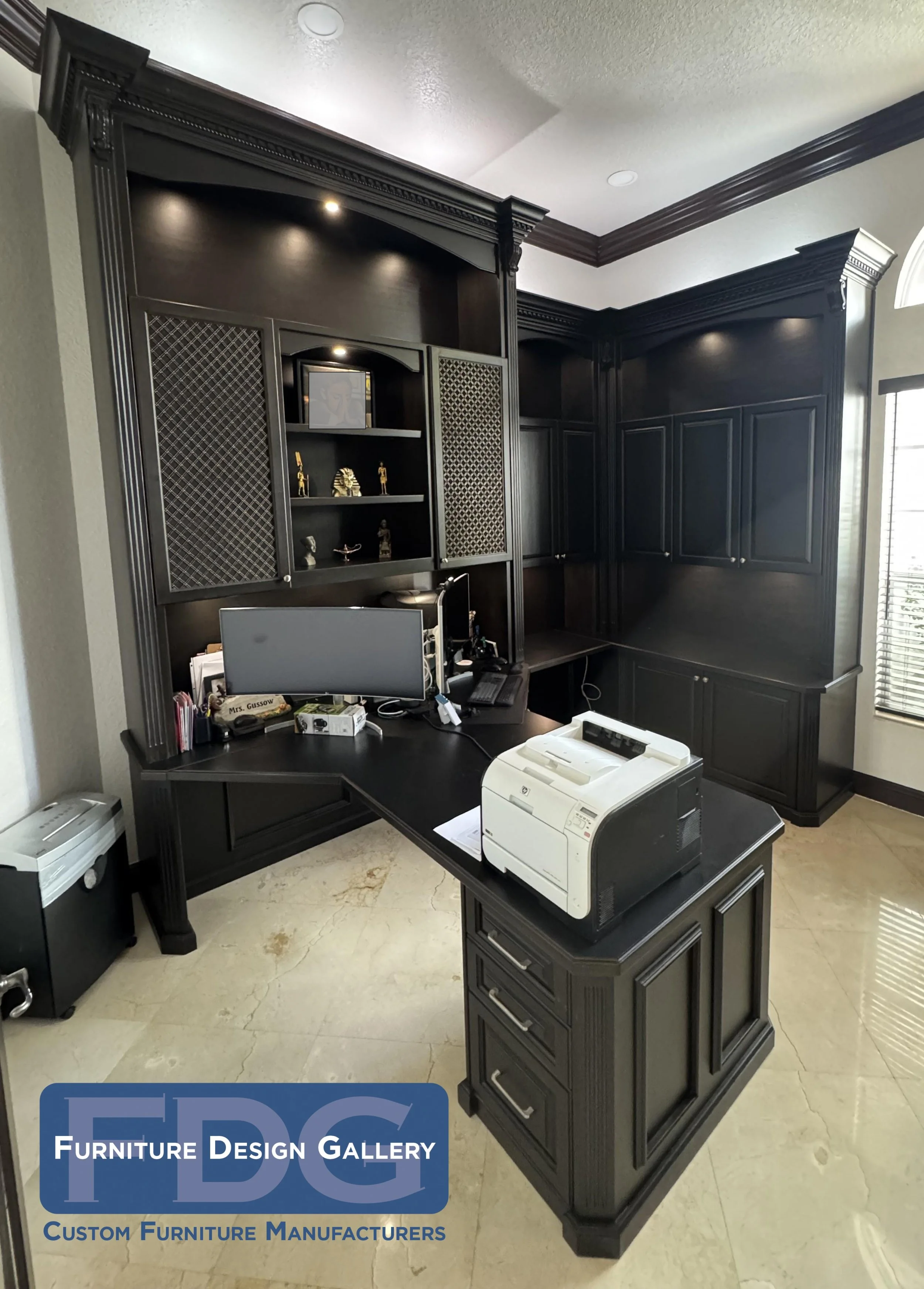 23.  A custom executive workspace built to fit the room perfectly. Complete with deep-toned cabinetry, classic crown molding, decorative mesh door inserts, and dedicated under-cabinet lighting.