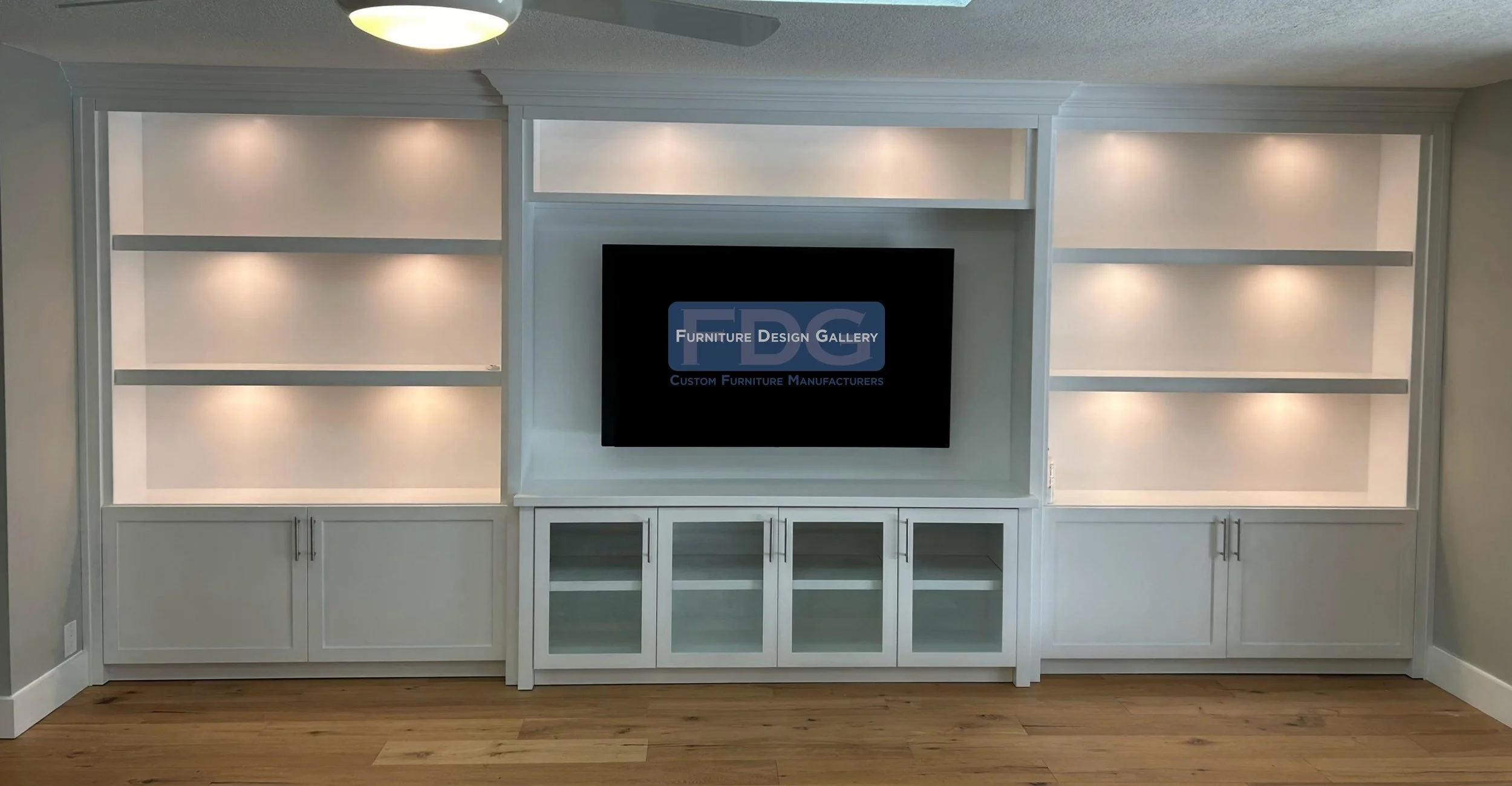 49. Elegant and timeless. This floor-to-ceiling wall unit features brilliant integrated lighting, glass-front cabinetry, and a clean white finish for a sophisticated focal point.