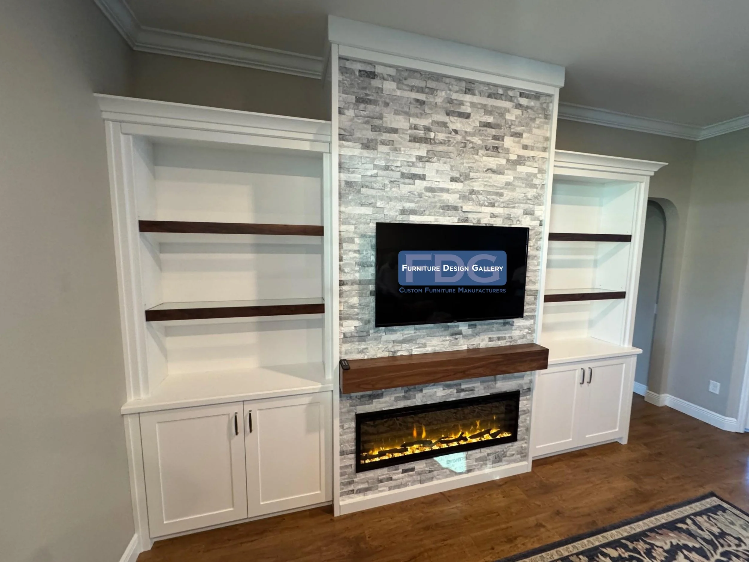 31. Clean lines and subtle textures define this sophisticated custom wall unit, featuring soft-lit shelving, a stacked stone TV backdrop, and a minimalist electric fireplace for a modern touch.