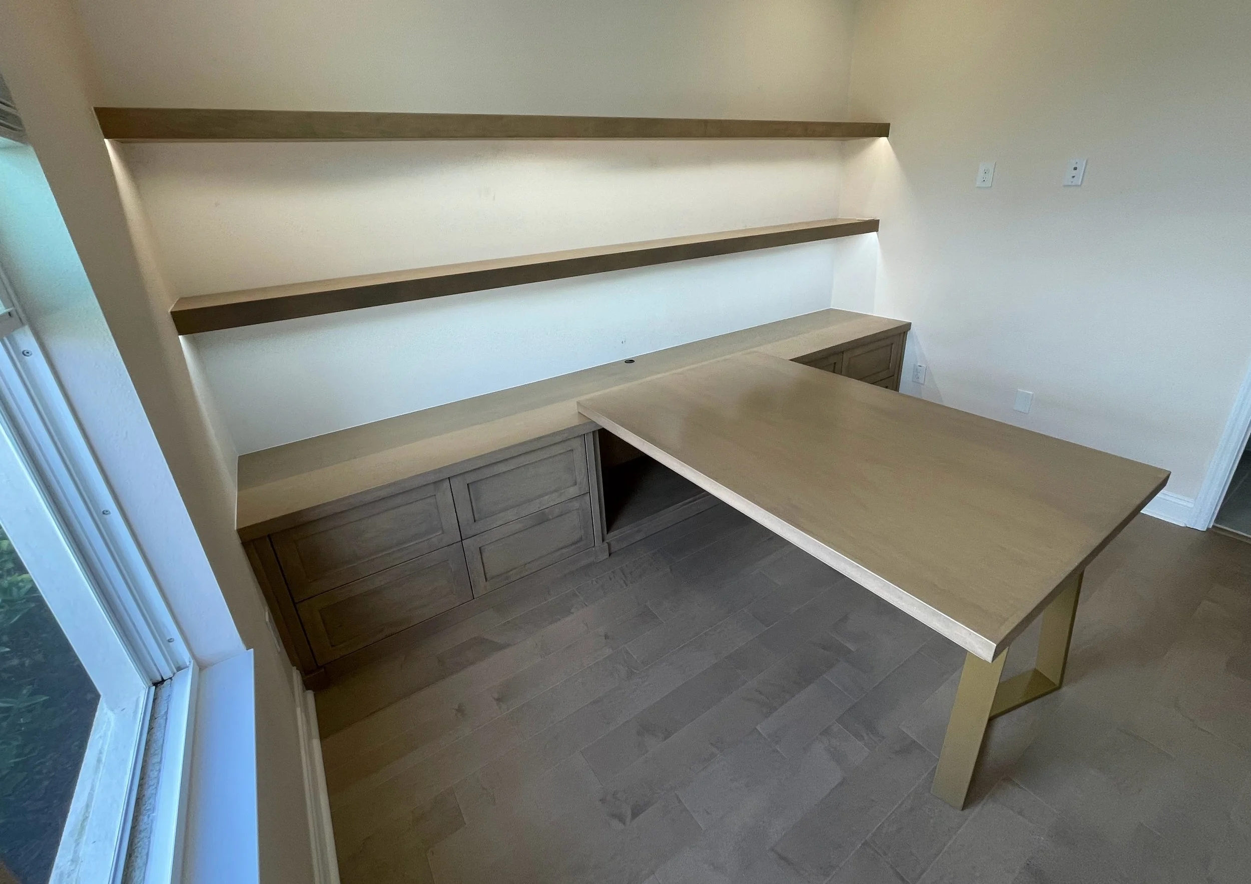 15. A workspace designed for connection. This sleek T-shaped partner's desk in a refined wood finish is perfectly complemented by minimalist floating shelves, complete with integrated LED lighting to create a focused, modern, and collaboratively func