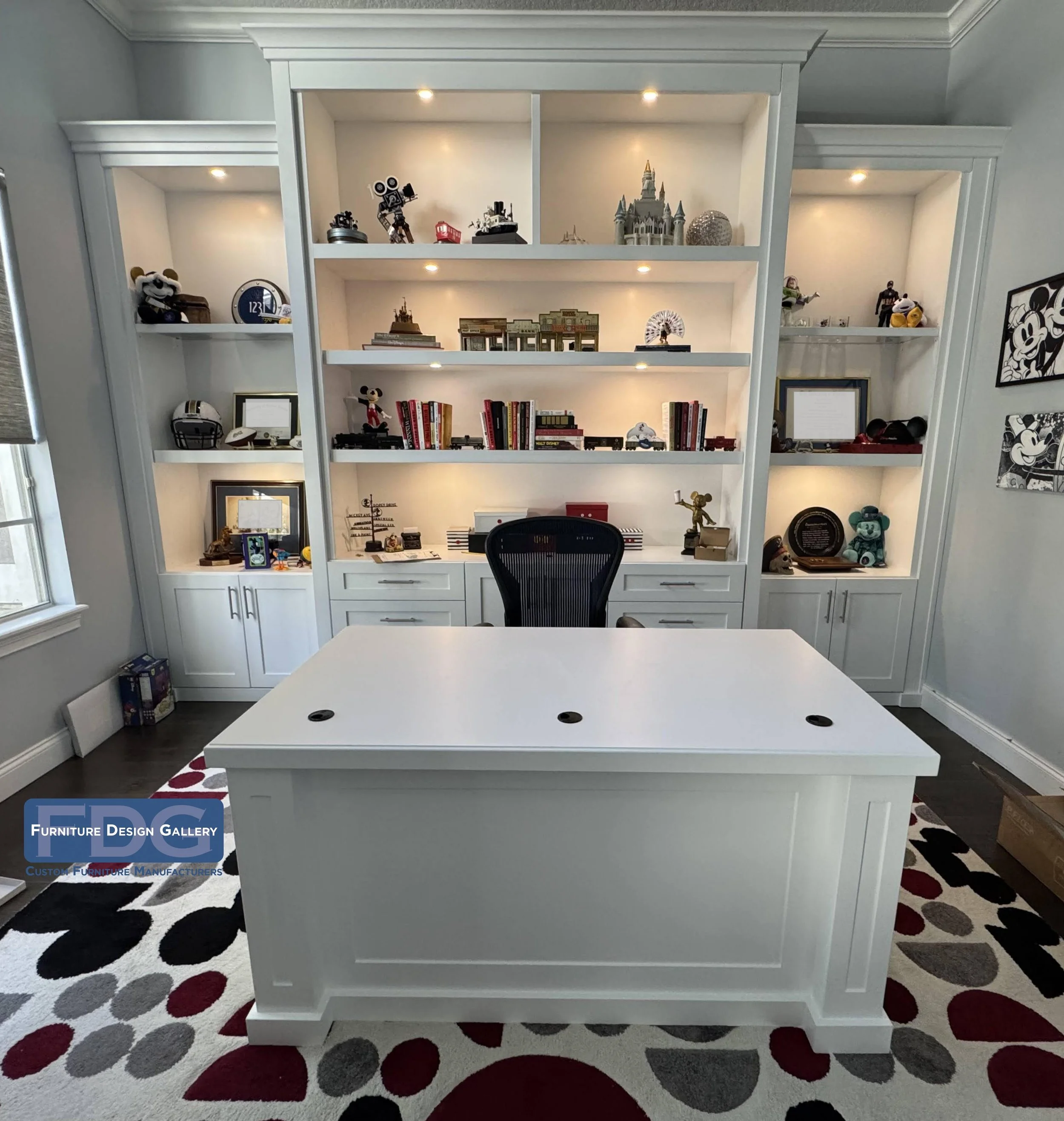 24.  Clean, bright, and completely custom. We paired this classic white double-pedestal desk with a matching floor-to-ceiling wall unit, complete with puck lighting, open shelving, and lower cabinets.