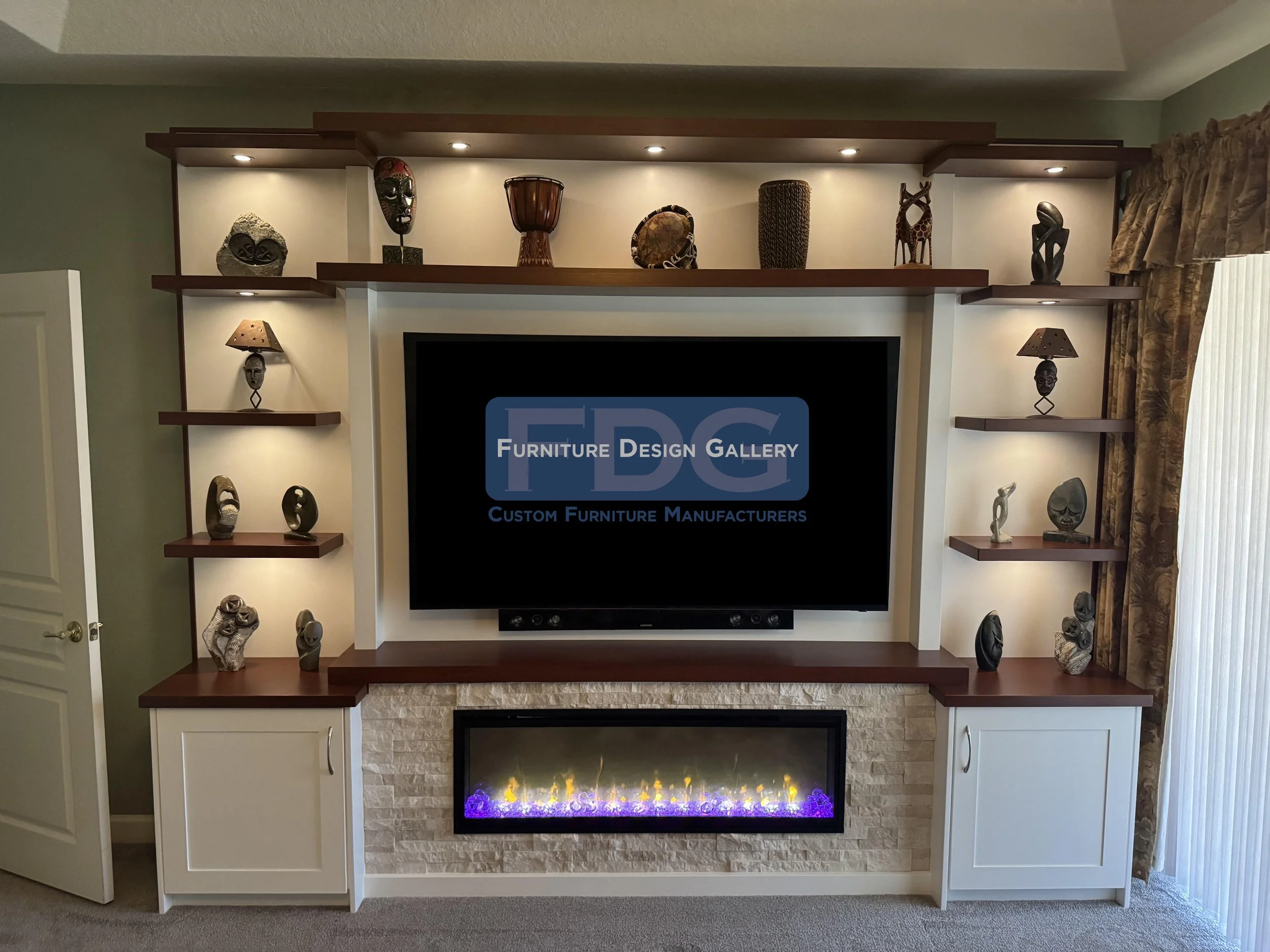 13. A stunning architectural statement. This custom wall unit integrates floating dark wood shelving, a stacked stone electric fireplace, and warm spotlighting to turn your media center into a gallery.