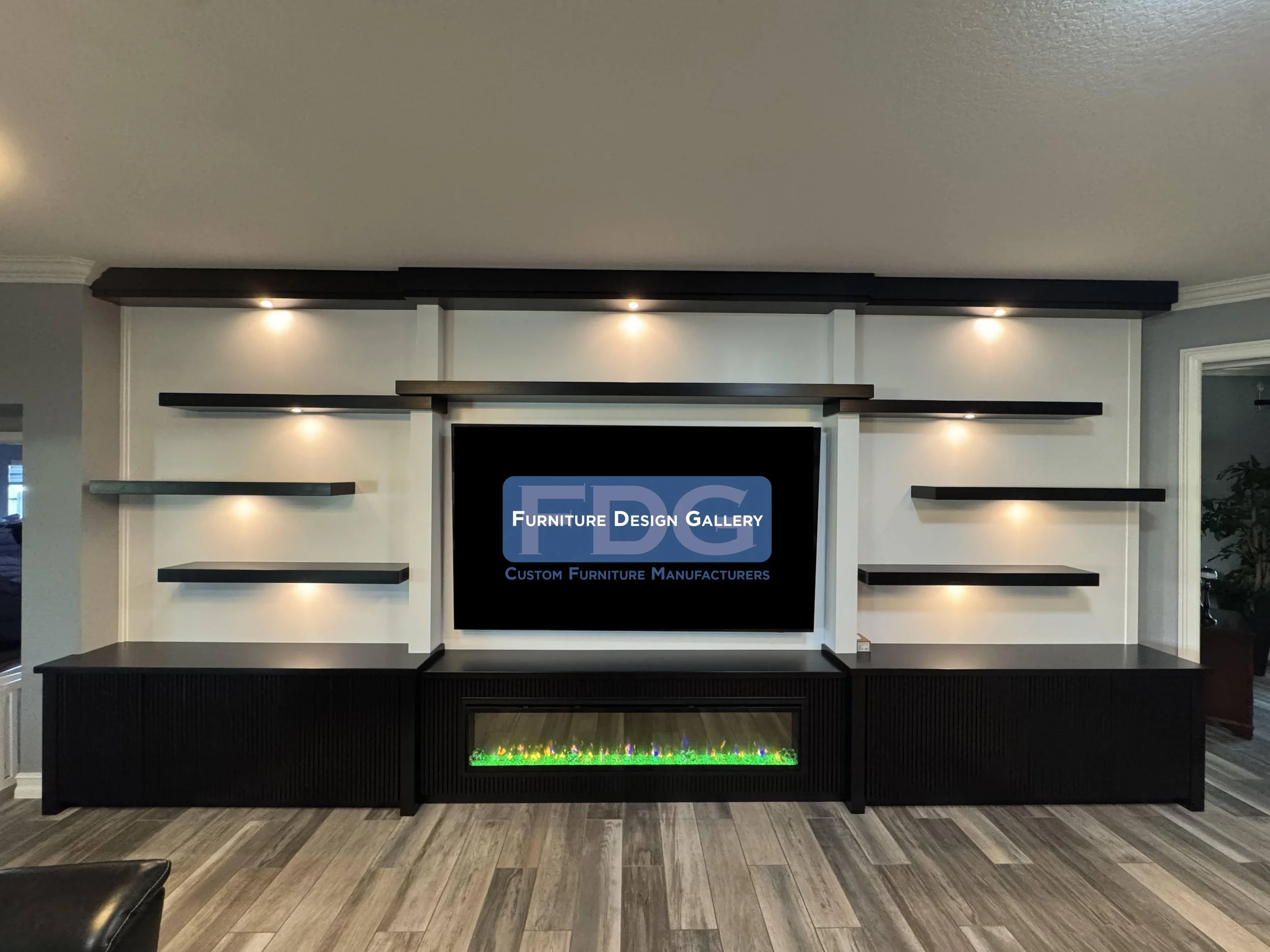 66. Make a bold statement with a contemporary custom entertainment center. This dramatic design pairs stark black cabinetry and floating shelves against a clean white backdrop, anchored by an integrated linear fireplace and brilliant accent lighting.