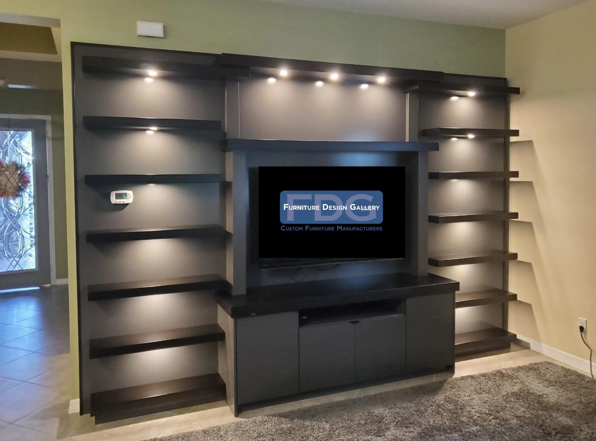 71.  Make a bold statement with this modern custom media center. The moody dark finish and floating shelves are elevated by integrated downlighting, creating a striking focal point for your living room.