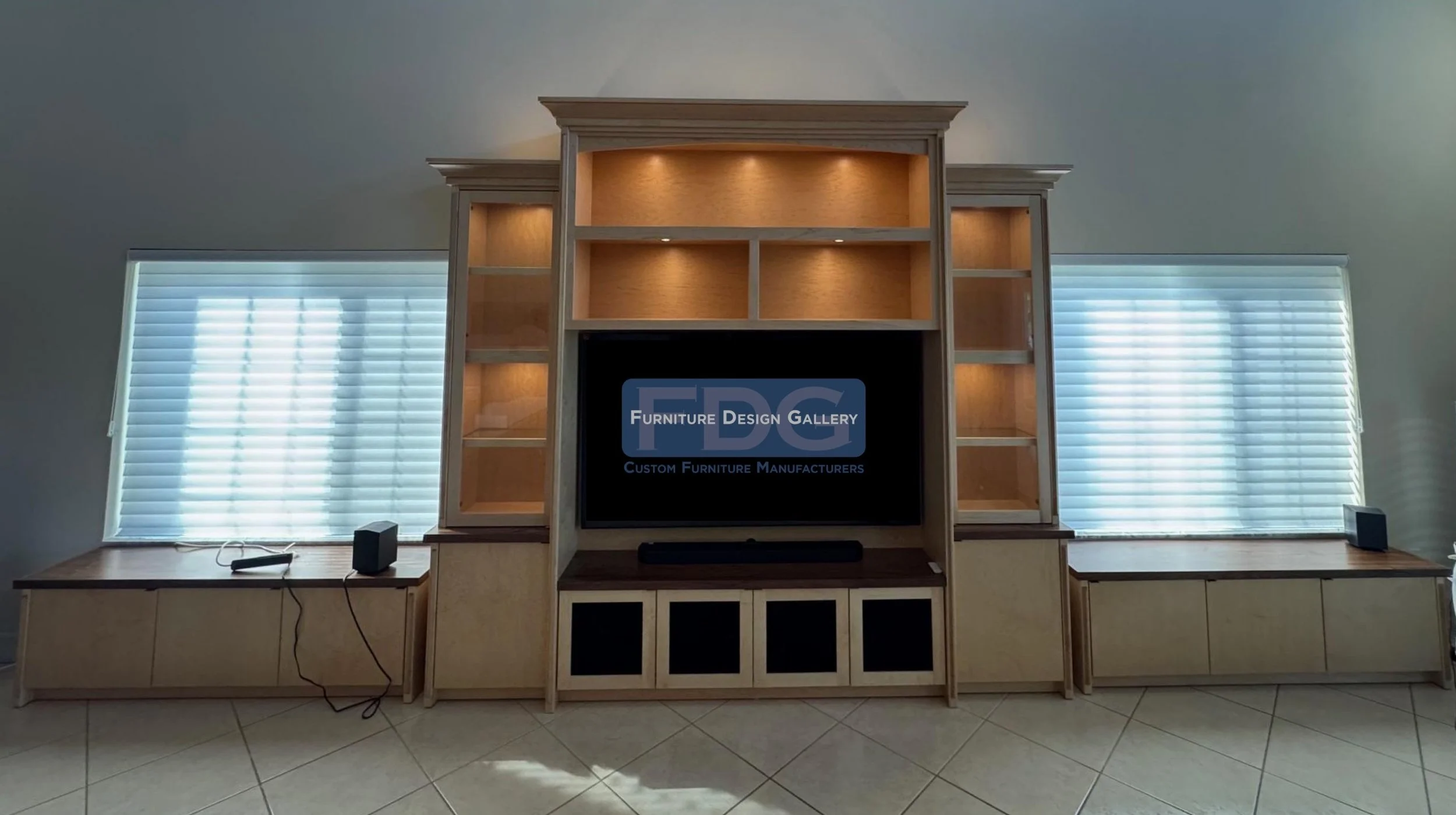 45. Warm, expansive, and thoughtfully designed. This custom light-wood wall unit features a central media hub with integrated puck lighting, glass-front display towers, and extended low-profile bench cabinetry that spans the room for maximum storage 