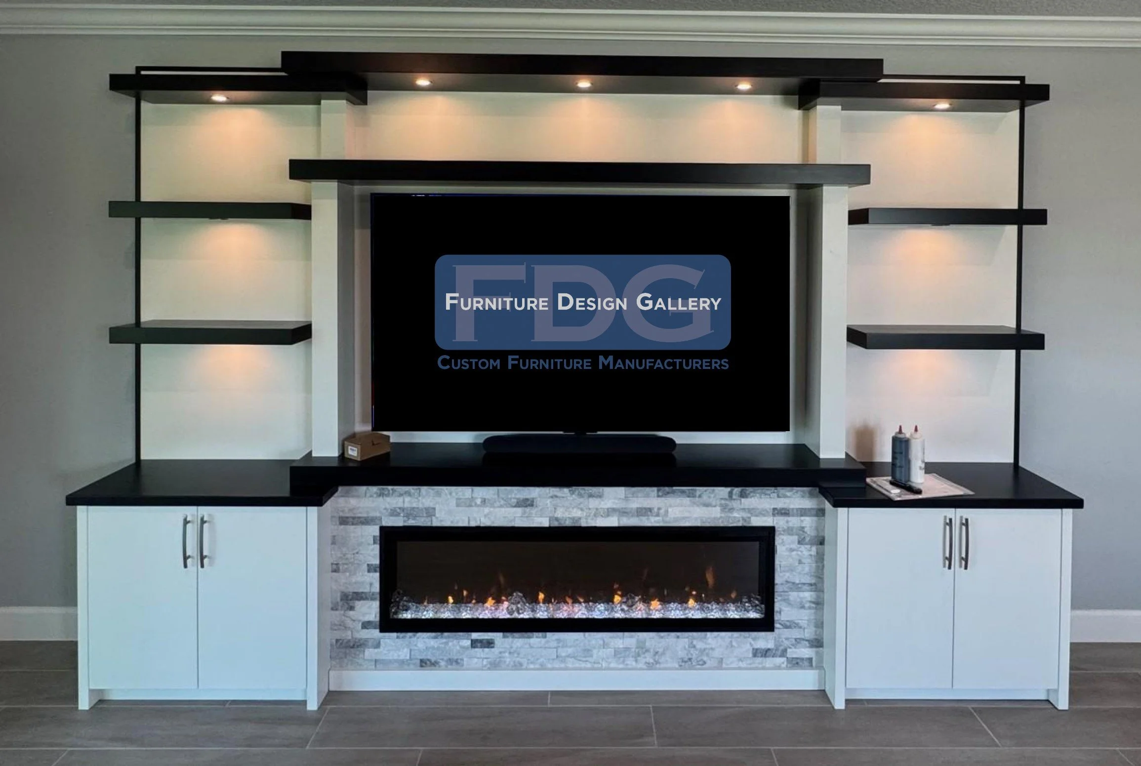 51. A masterclass in contrast. This custom wall unit blends deep black accents with a crisp white finish, anchored by a stunning stone-surround fireplace and warm integrated shelving lights.