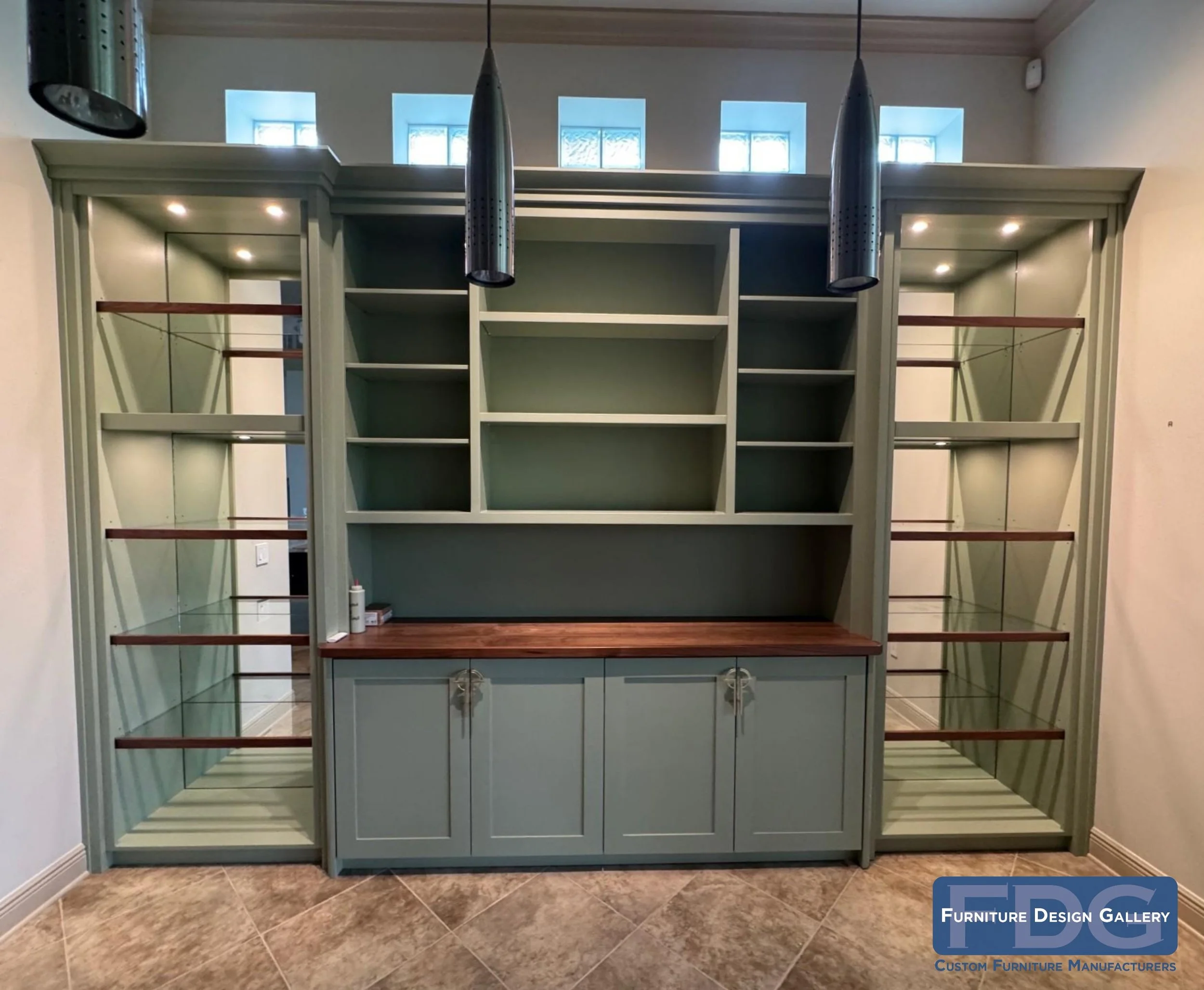 3. Elevate your space with a perfect blend of modern lines and timeless craftsmanship. This custom-built unit features a sophisticated sage green finish, rich walnut accents, and integrated LED lighting to showcase your favorite pieces.