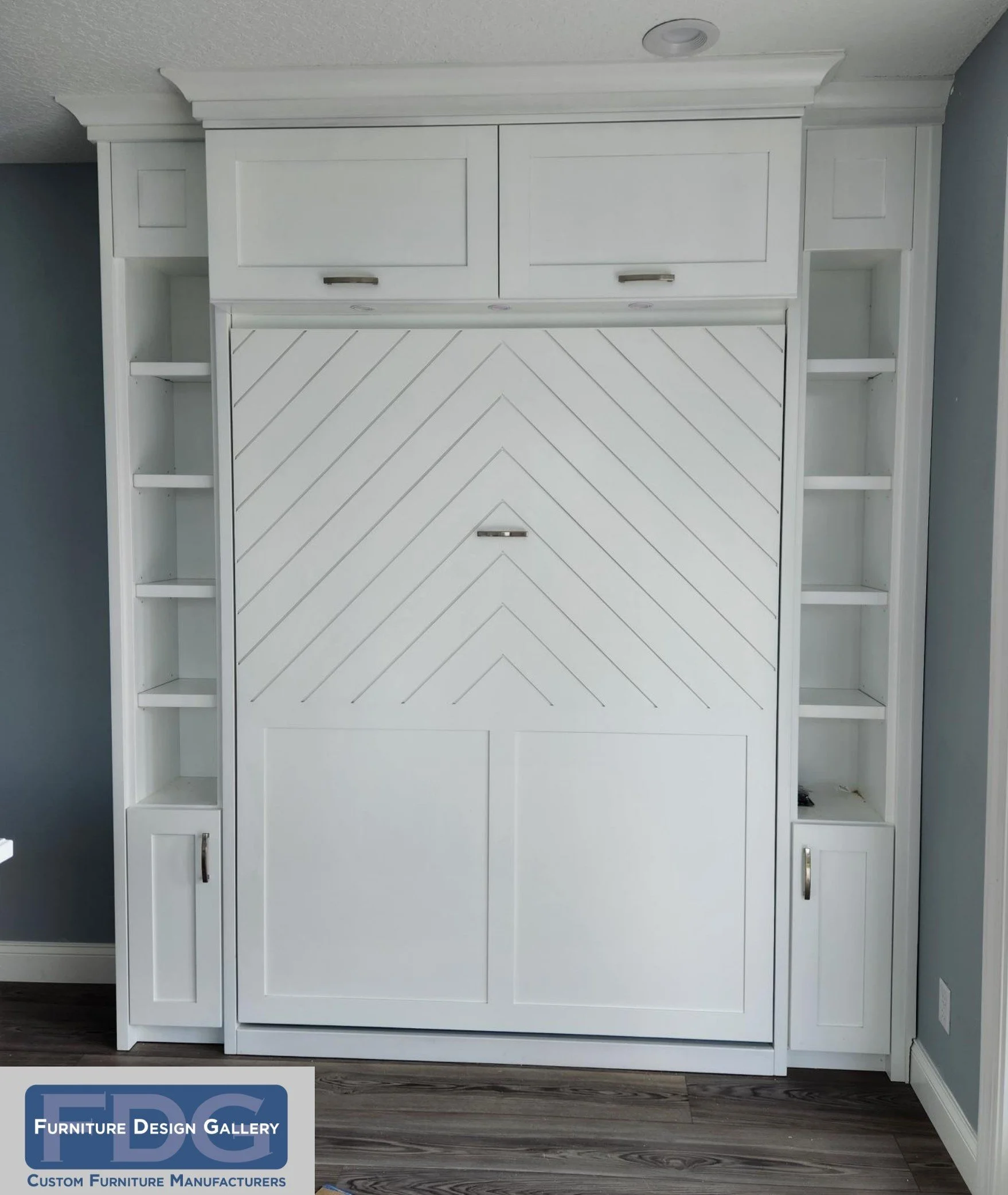 2. Style meets space-saving genius. This custom Murphy bed features a striking chevron-patterned face and integrated side shelving, offering a seamless and elegant solution for any multi-purpose room.