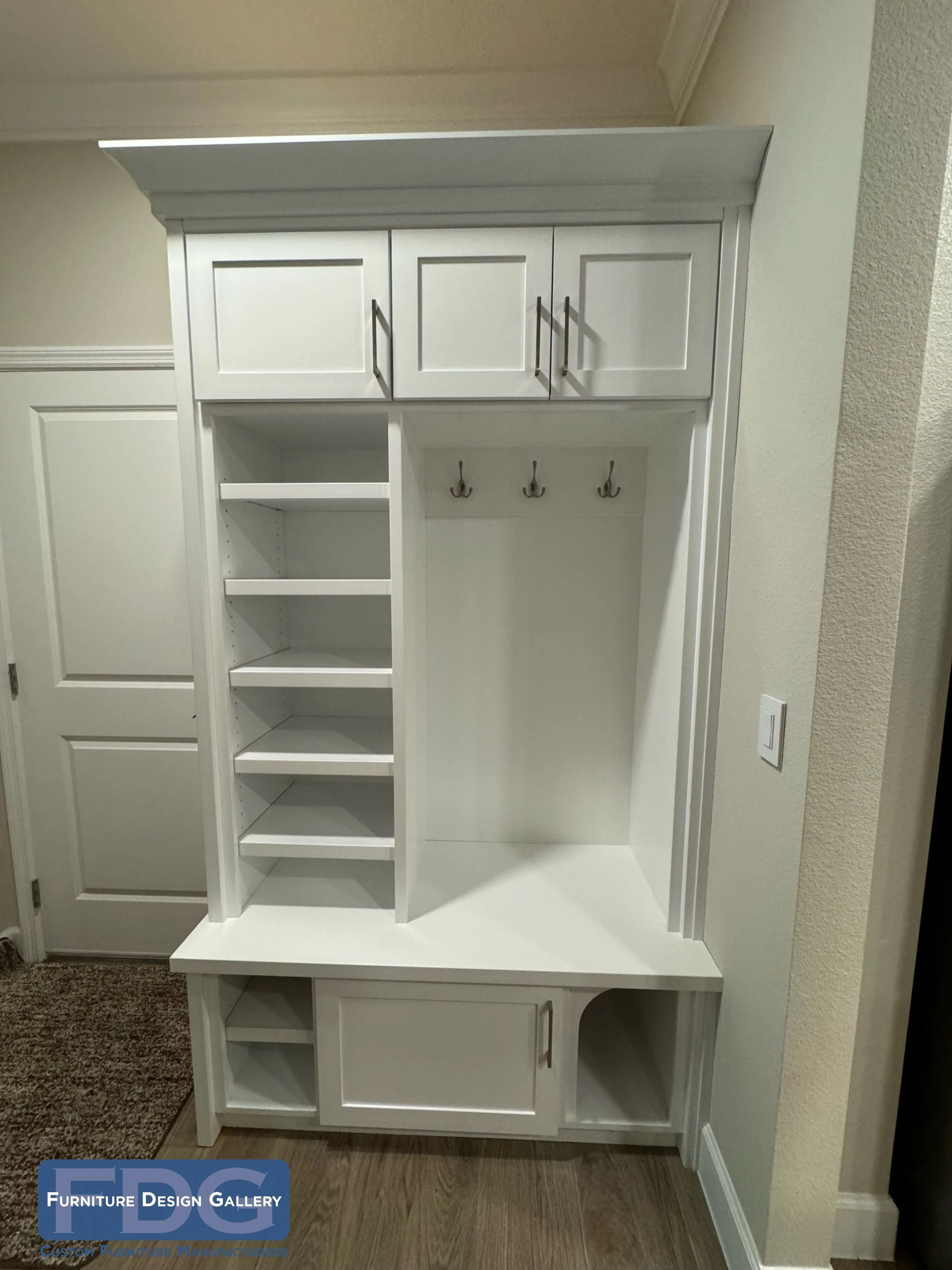 6. The ultimate mudroom multitasker. This custom white built-in combines sleek storage and coat hooks with a cleverly hidden, integrated litter box enclosure for a clean and pet-friendly entryway.