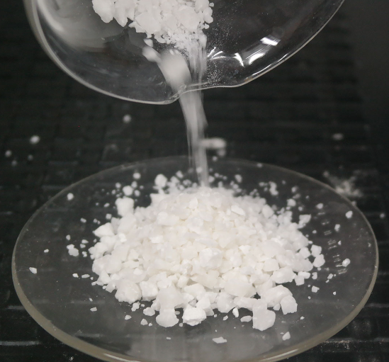 Salt being poured onto a clear glass plate from a bowl.
