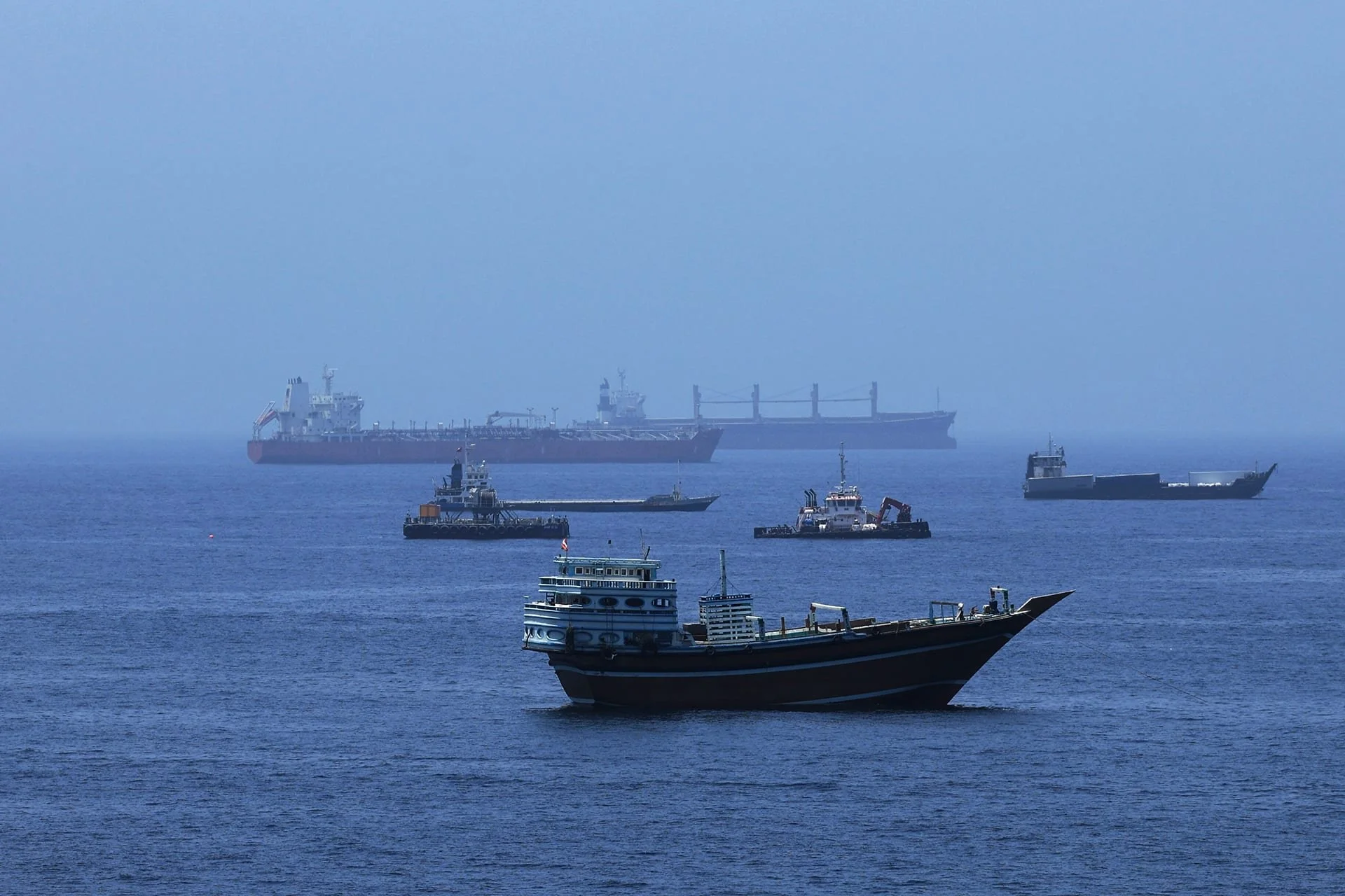 Tankers, cargo ships, and smaller vessels moving through the Strait of Hormuz.