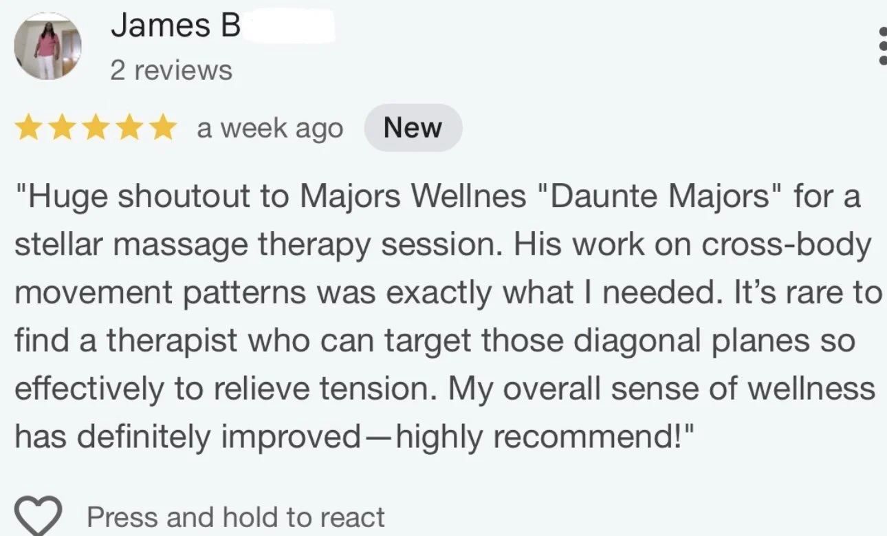 Mountain landscape with snow-capped peaks and a building on a grassy hill in the foreground.