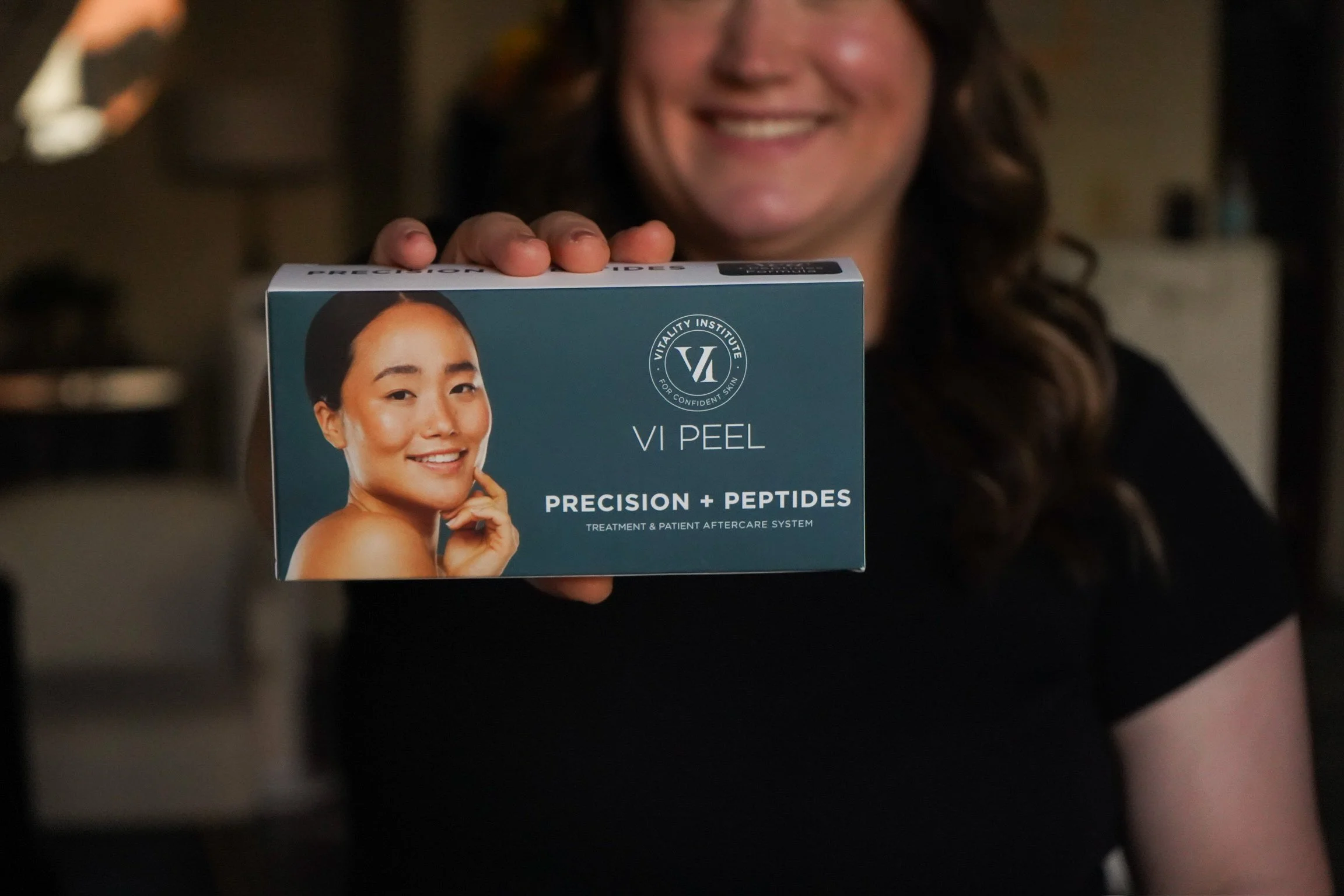 A woman receiving a cosmetic injection from a healthcare professional using a specialized instrument in a clinical setting.