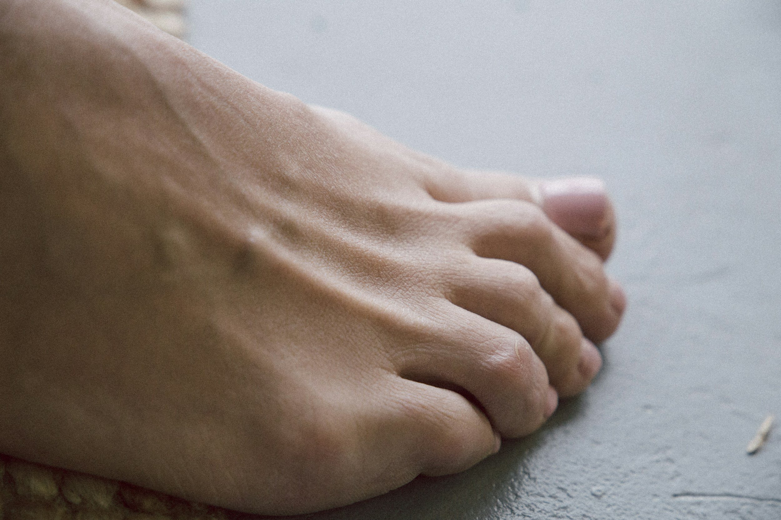 Close-up of a human hand with fingers resting on a flat surface.