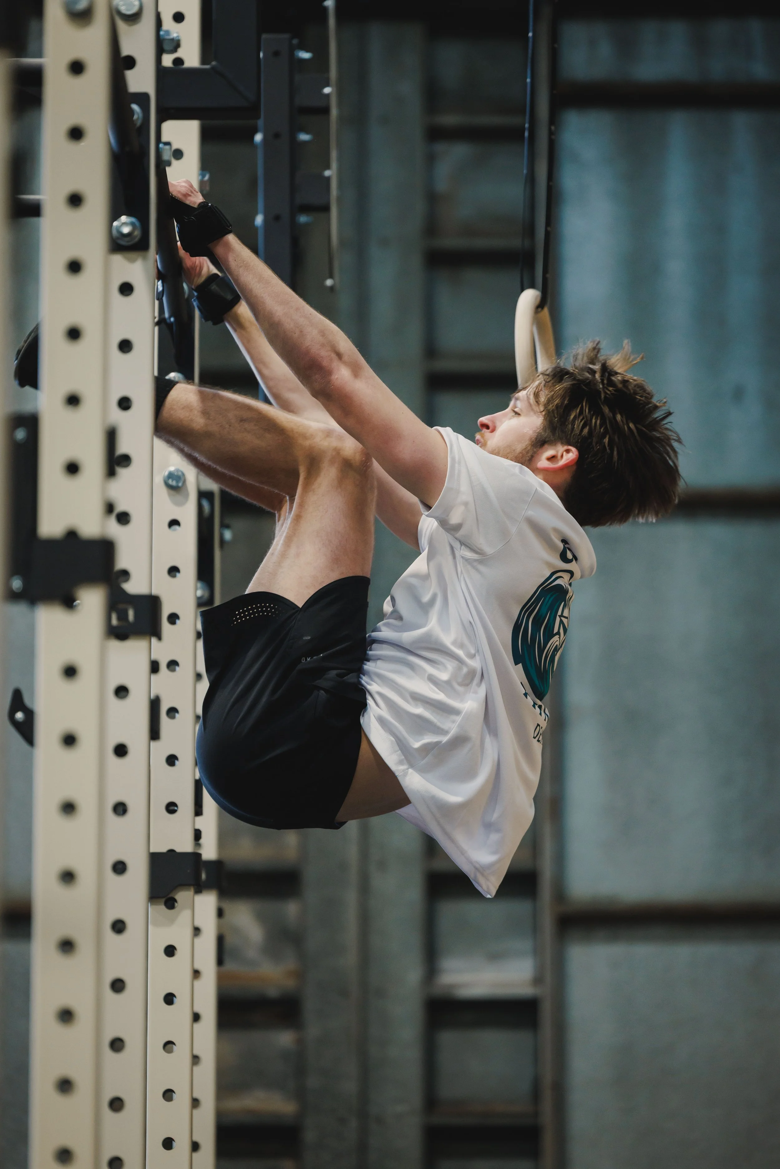 Young man doing toes to bar on a CrossFit rig.