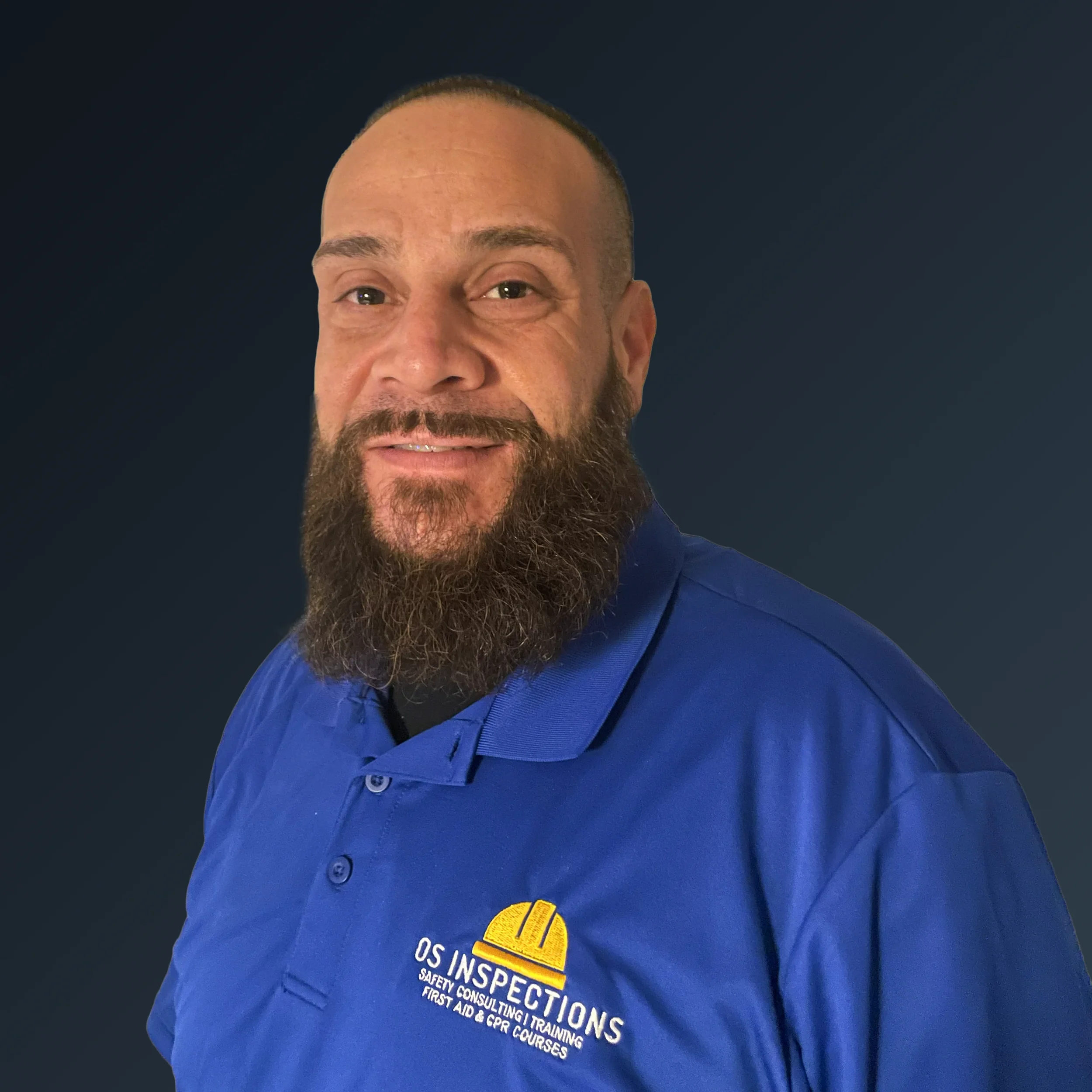 A man with a beard wearing a blue uniform shirt with a yellow helmet logo and the text "OS INSPECTIONS" and related services, standing against a dark background.