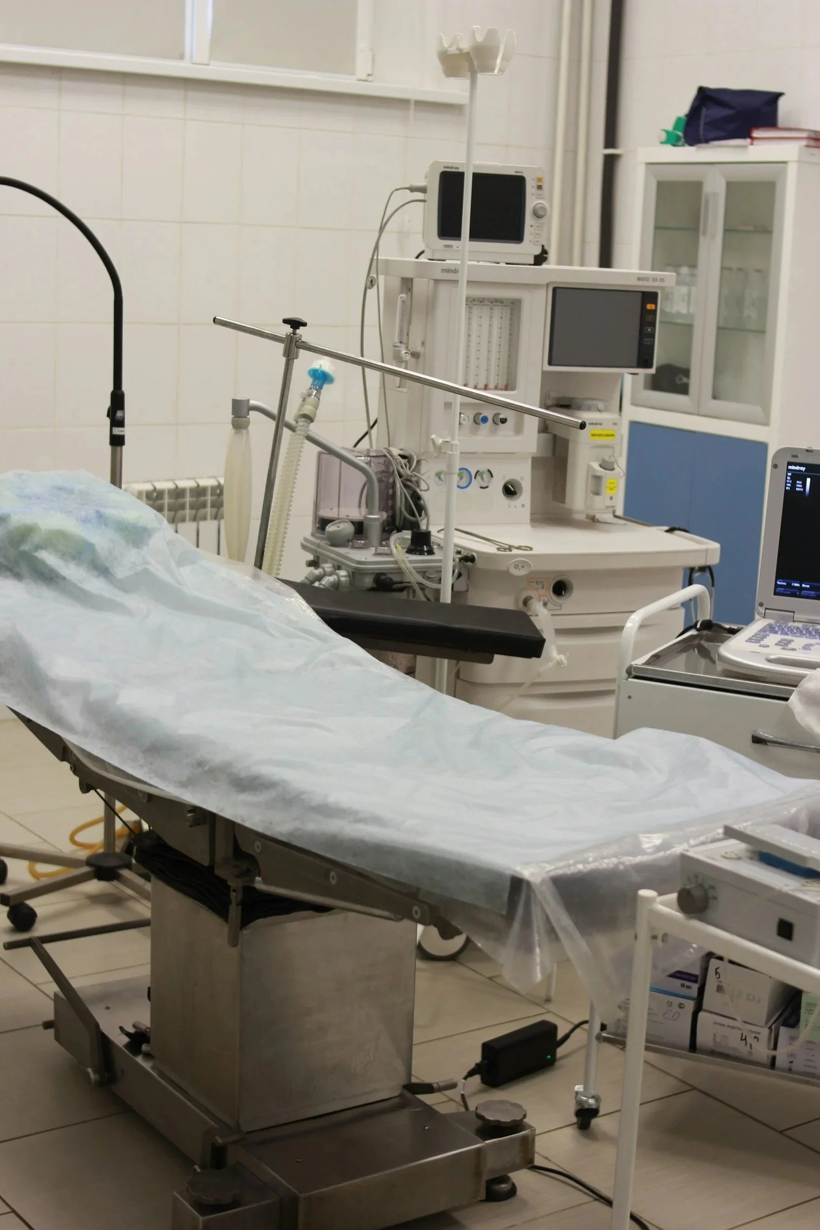 Ein leeres Operationstisch im Operationssaal mit medizinischer Ausrüstung und Überwachungstechnik.