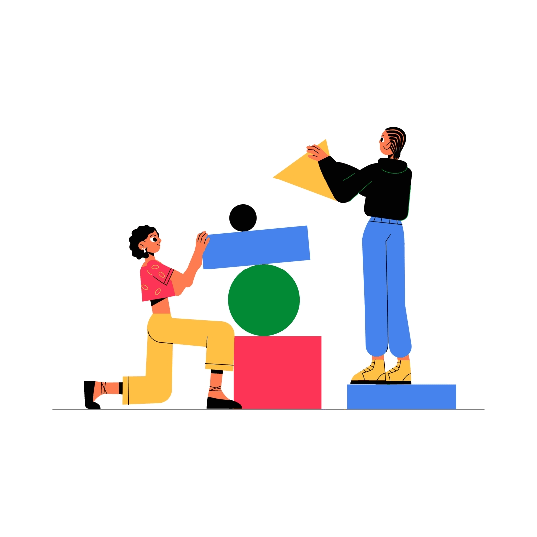 Two women constructing a tower with colorful geometric shapes, one kneeling and the other standing.
