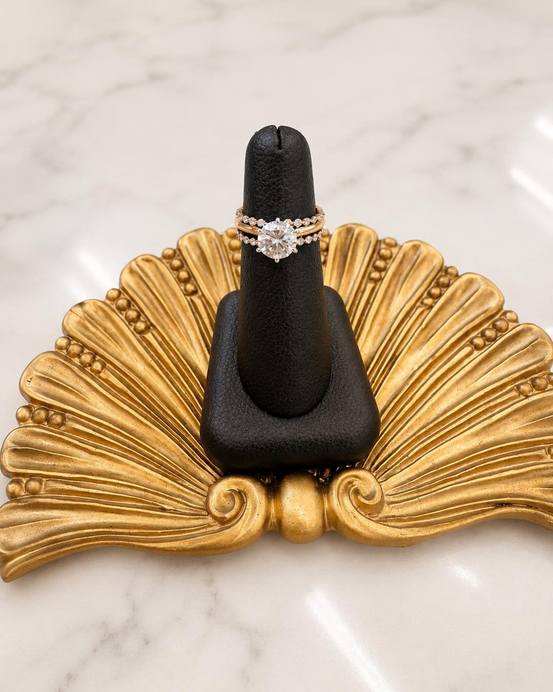 A love story told in diamonds! Featuring a natural round solitaire set in yellow gold with two floating diamond bands that add just the right touch of sparkle! ✨💍