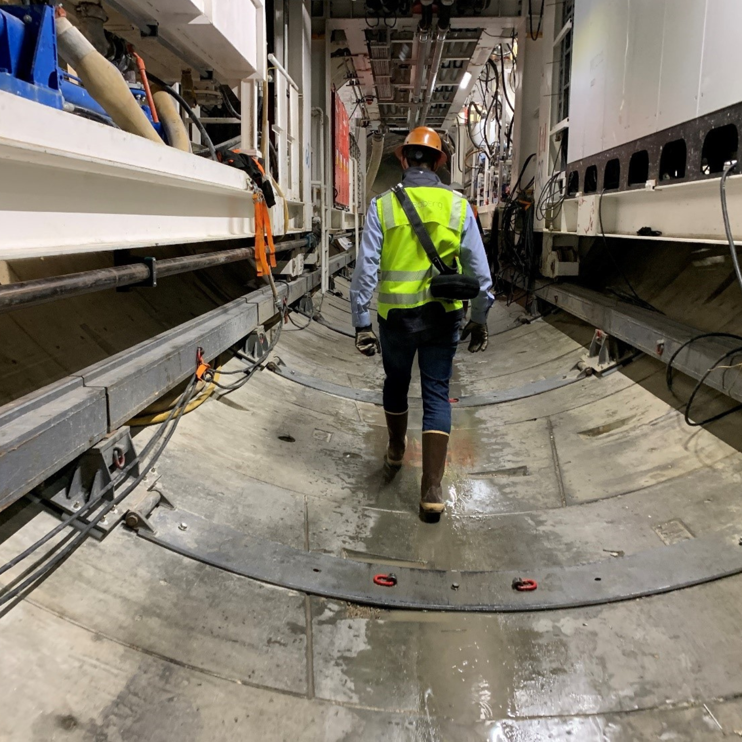 Mining staff member walking underneath the tunnel boring machine's trailing gear.
