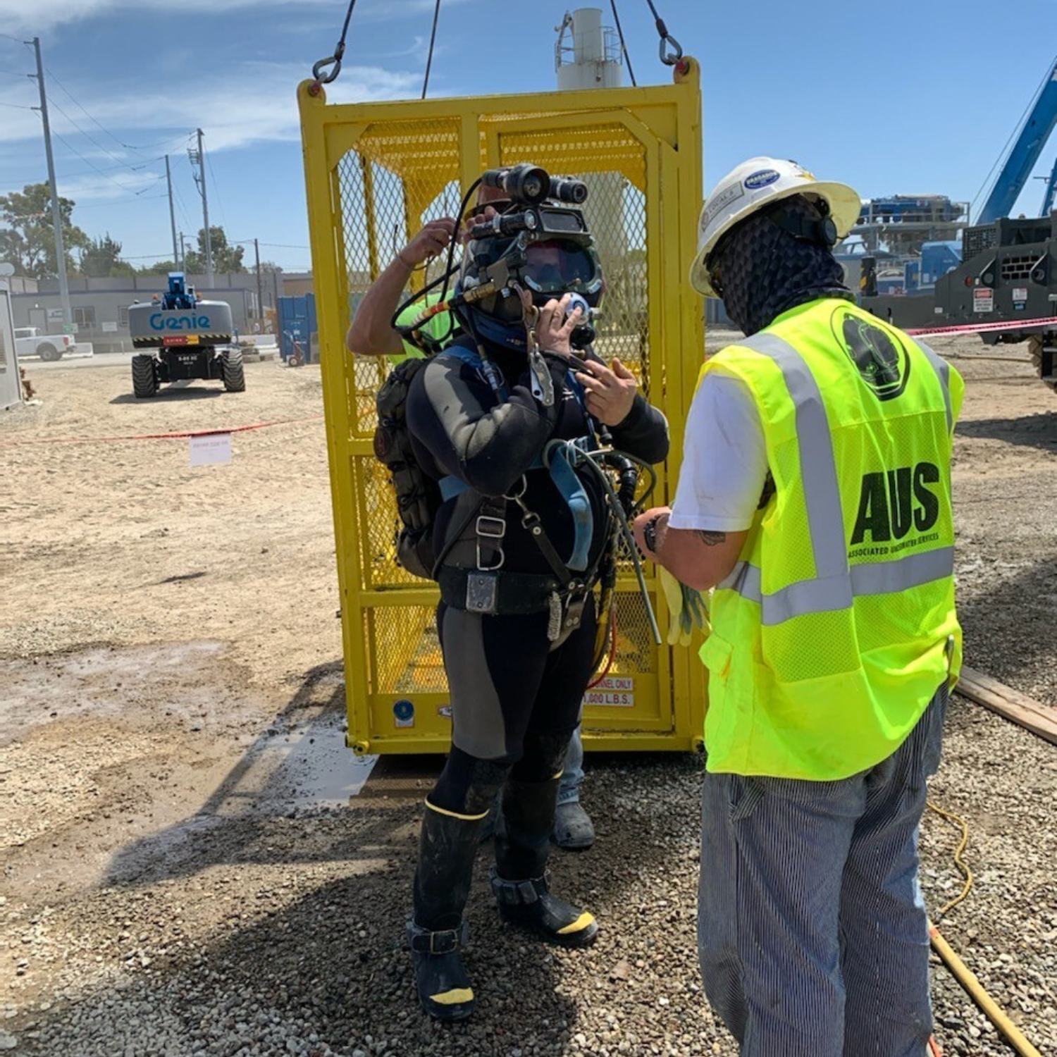 Scuba diver inspecting rebar at the bottom of the shaft with a staff member assisting before tremie operation.
