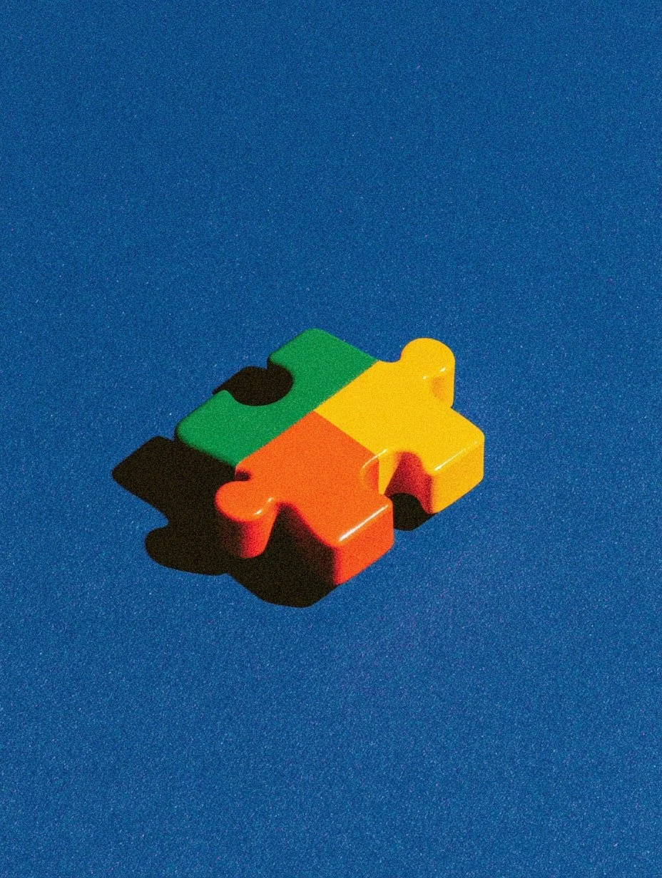 Colorful plastic puzzle piece shaped like a jigsaw puzzle piece on a blue surface.