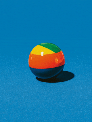 Colorful beach ball on a blue surface with a clear blue sky background.