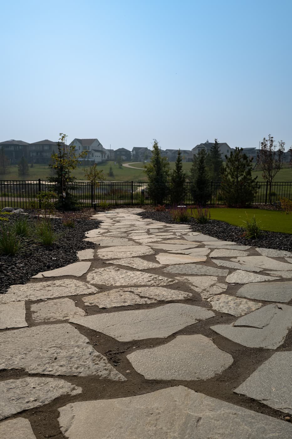 Custom natural flagstone walkway leading to greenspace
