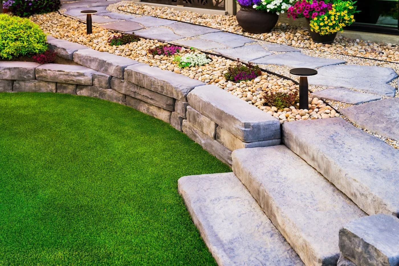 Retaining wall and steps landing on artificial turf in Barkman Pacific Grey
