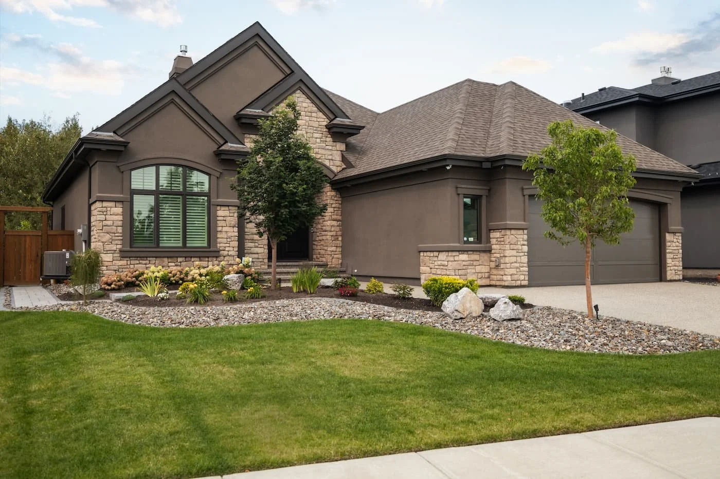 Fully custom landscaped front yard with gardne beds, boulders, rock, shrubs and trees