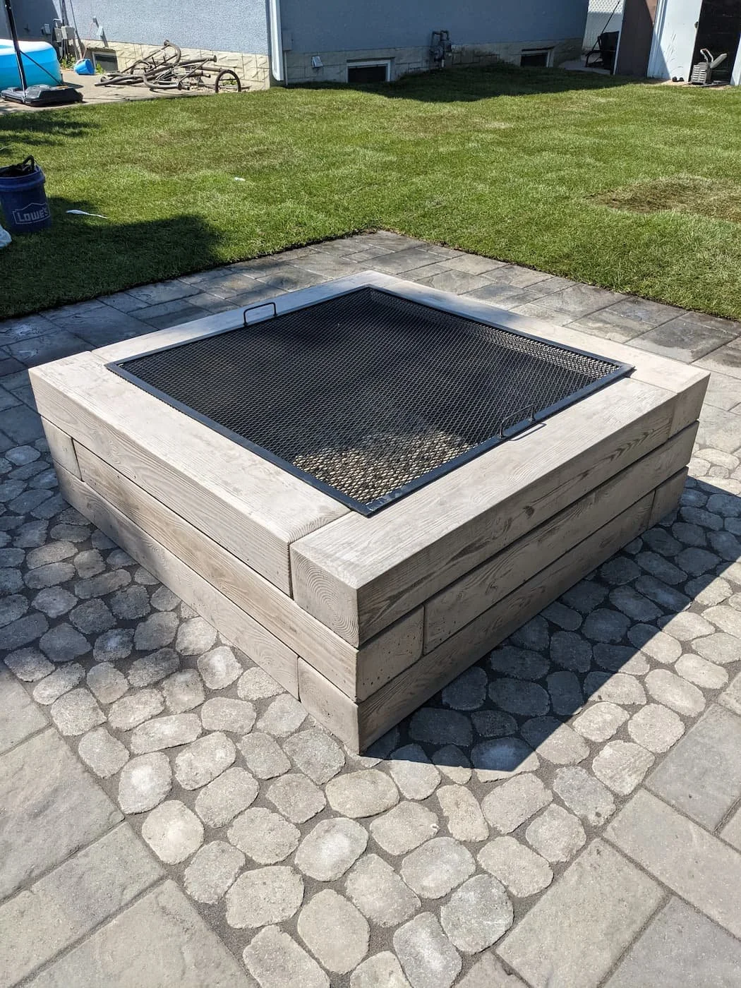 Custom borealis woode burning fire feature on a paving stone patio