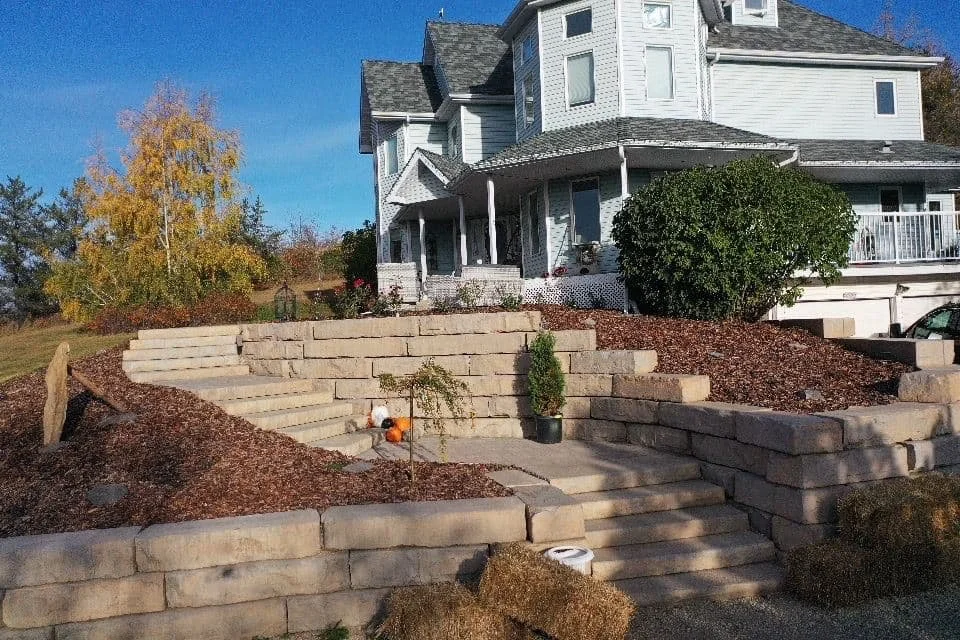 Large beige retaining wall with multiple steps leading to a front door