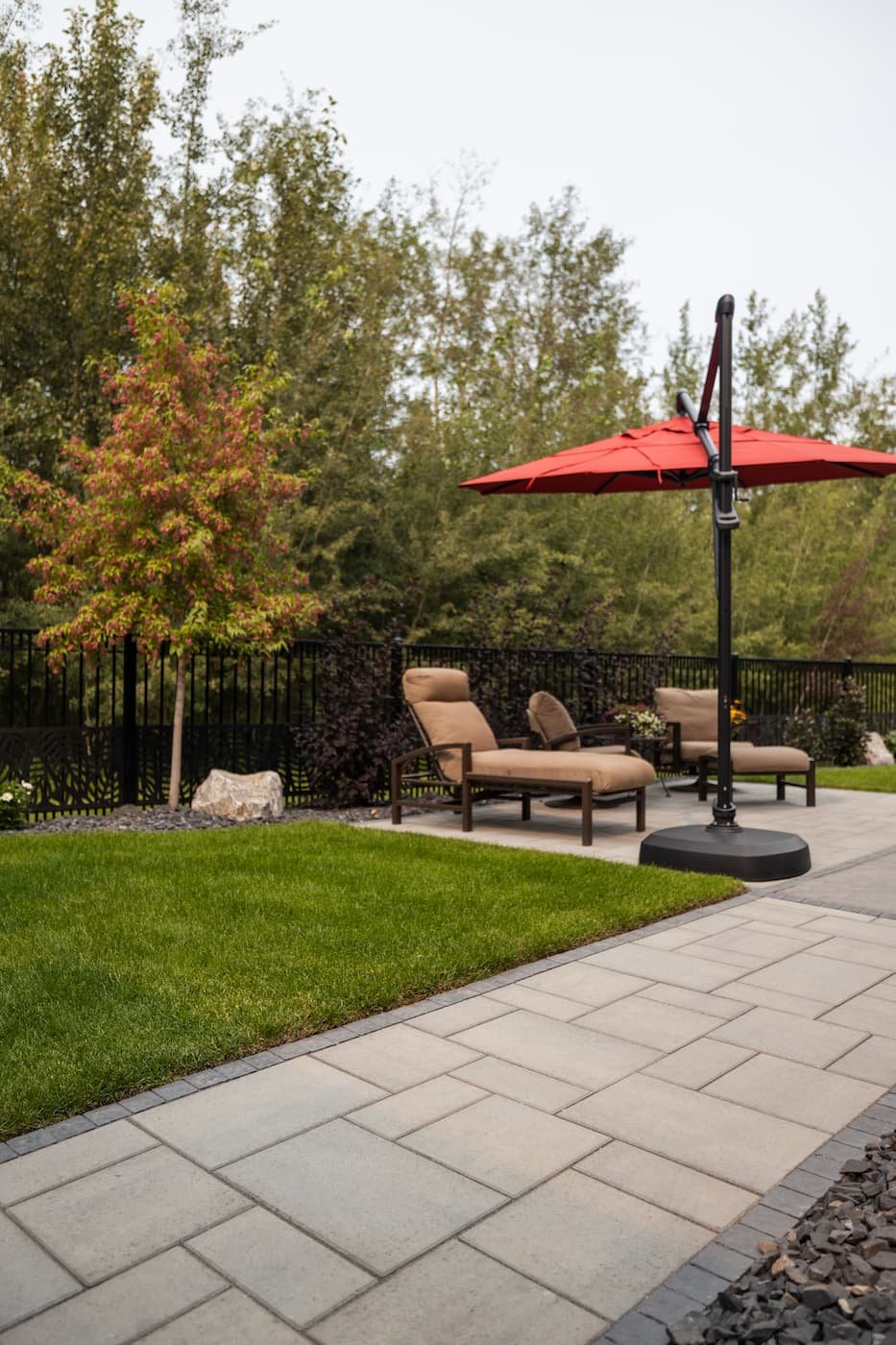 Backyard walkway leading to a paving stone patio with smooth paving stones
