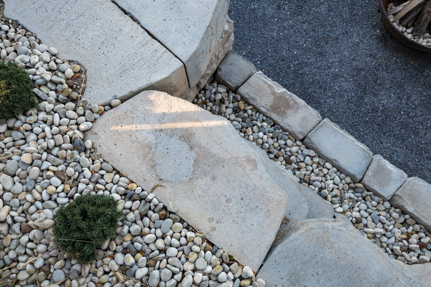 River rock and shrubs on a two tierd retaining wall