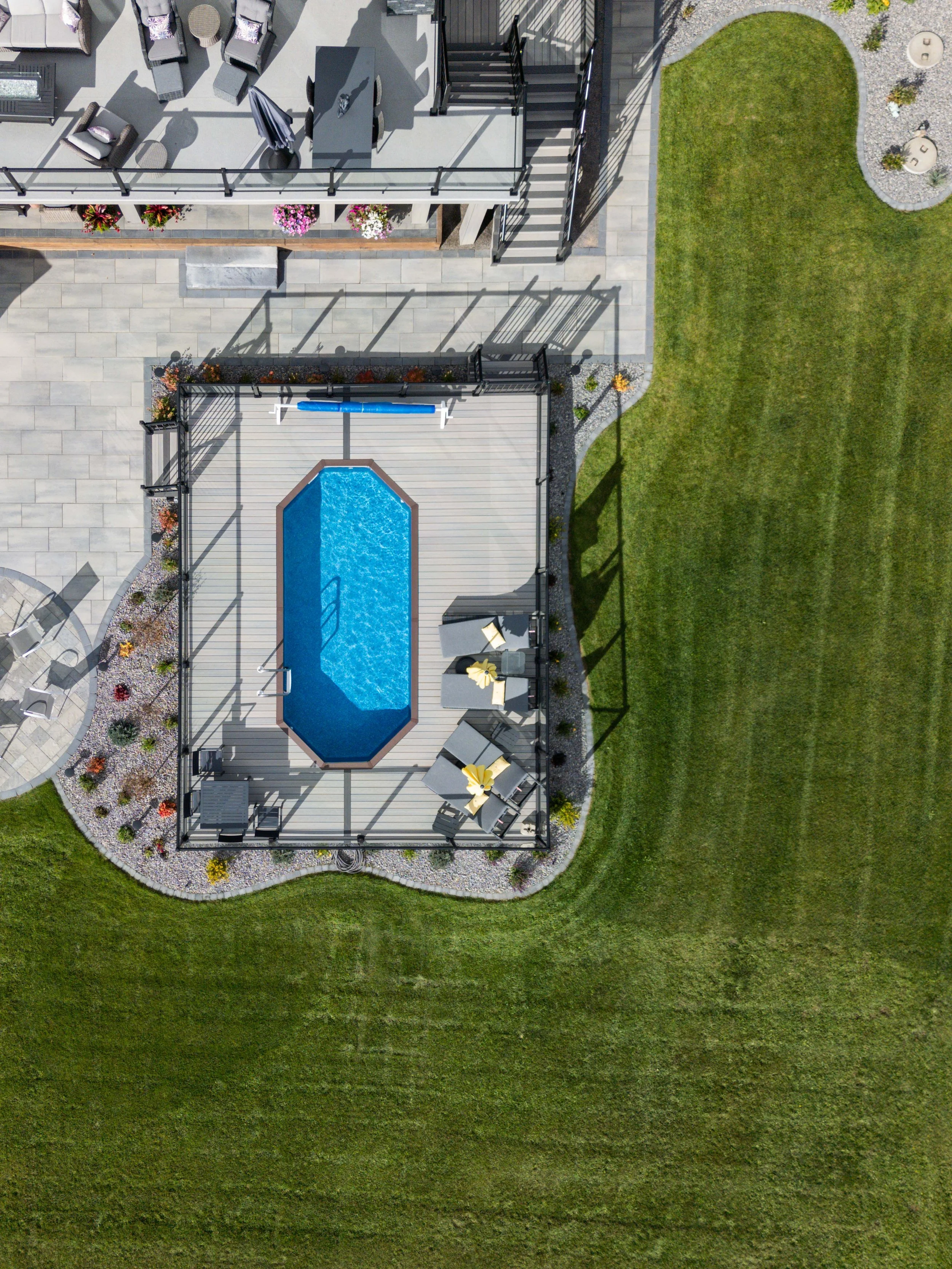 Large backyard with a pool and hardscaped patio
