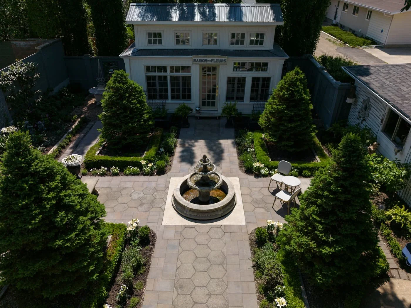 A feminine backyard with a water feature and 't' shaped patio with seating
