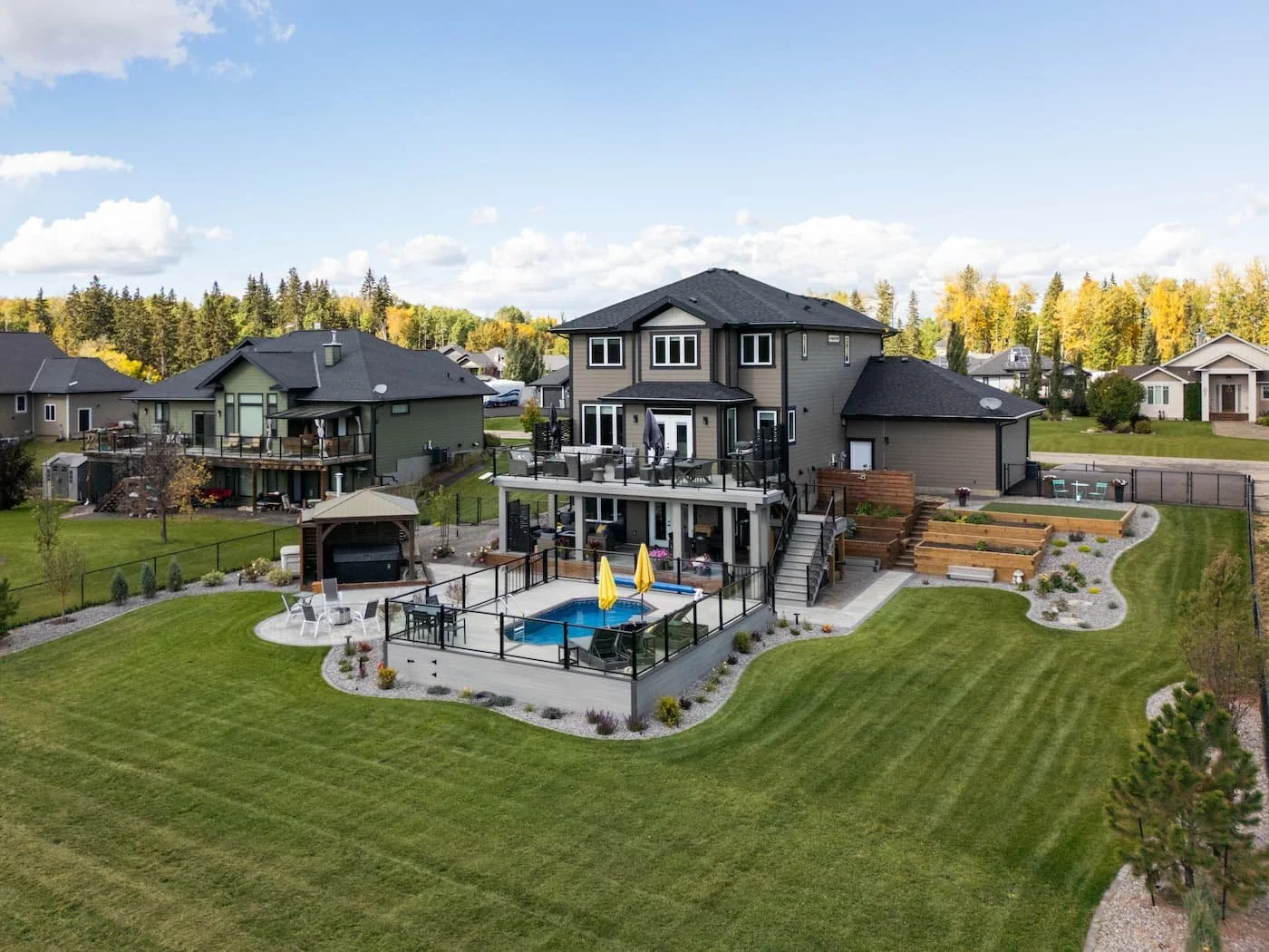 Large fully landscaped backyard showing limestone rock, hardscaping, juniper trees and perennials