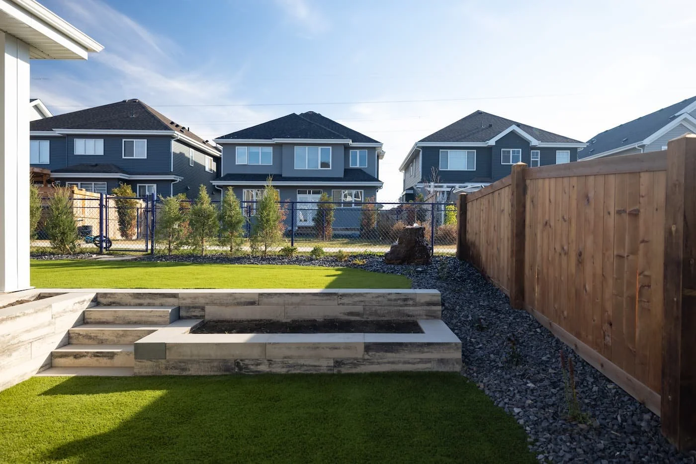 Tiered backyard with artificial turf and limestone