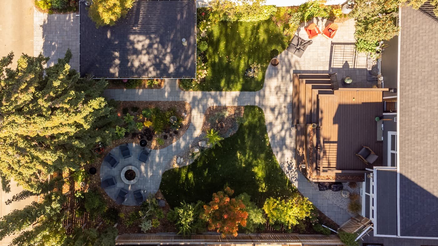 Backyard with a cozy circle patio and firepit with paving stone walkways