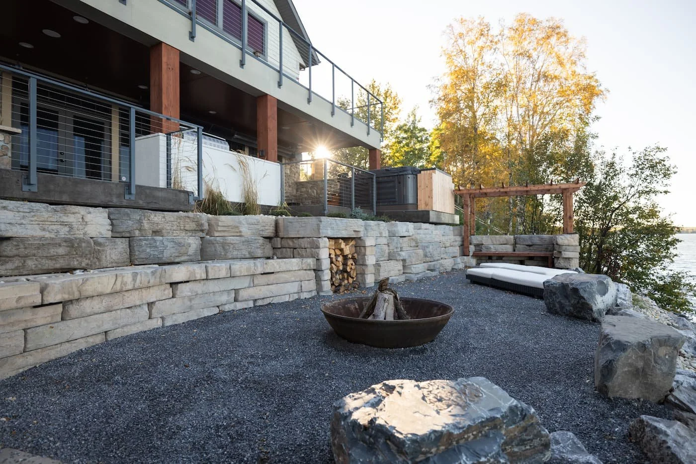 Fully landscaped lake front yard with retaining wall, boulders, limestone and a firepit