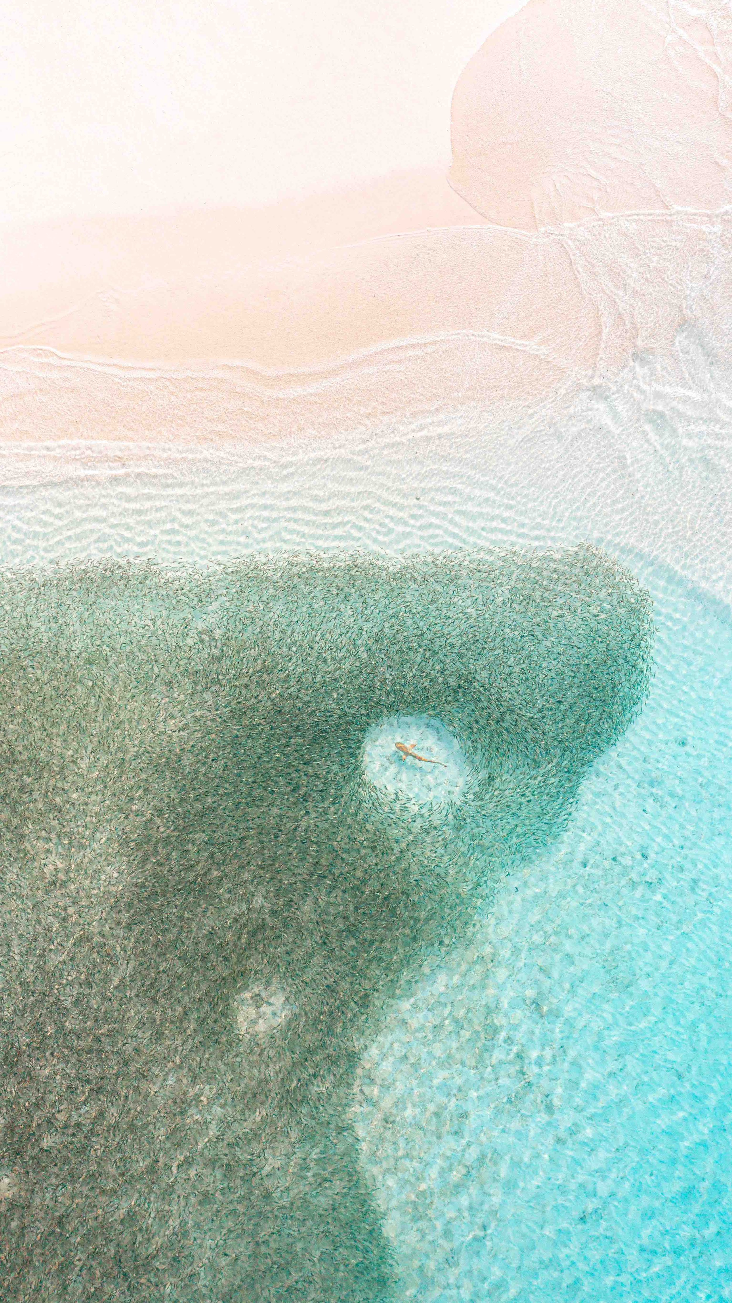 Aerial view of a person lying on a bubble bath with colorful bubbles.