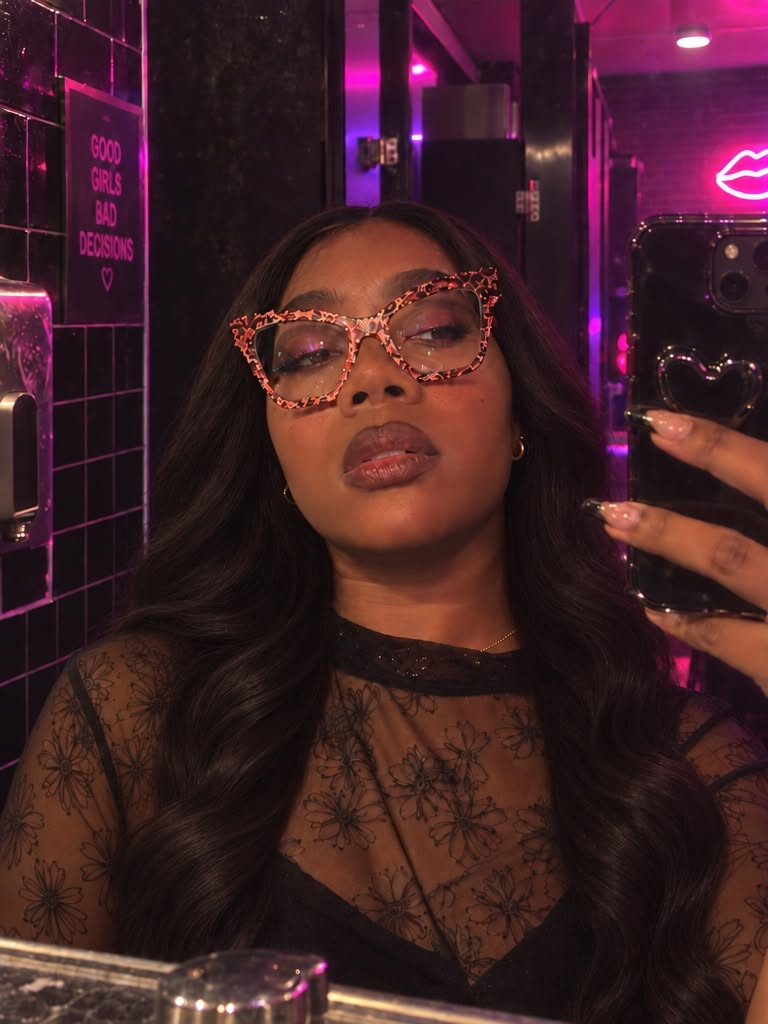 Lanice Xo taking a mirror selfie under pink neon lights