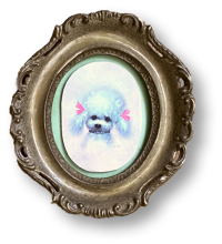 A small, cute puppy with blue fur and pink highlights in a decorative oval frame