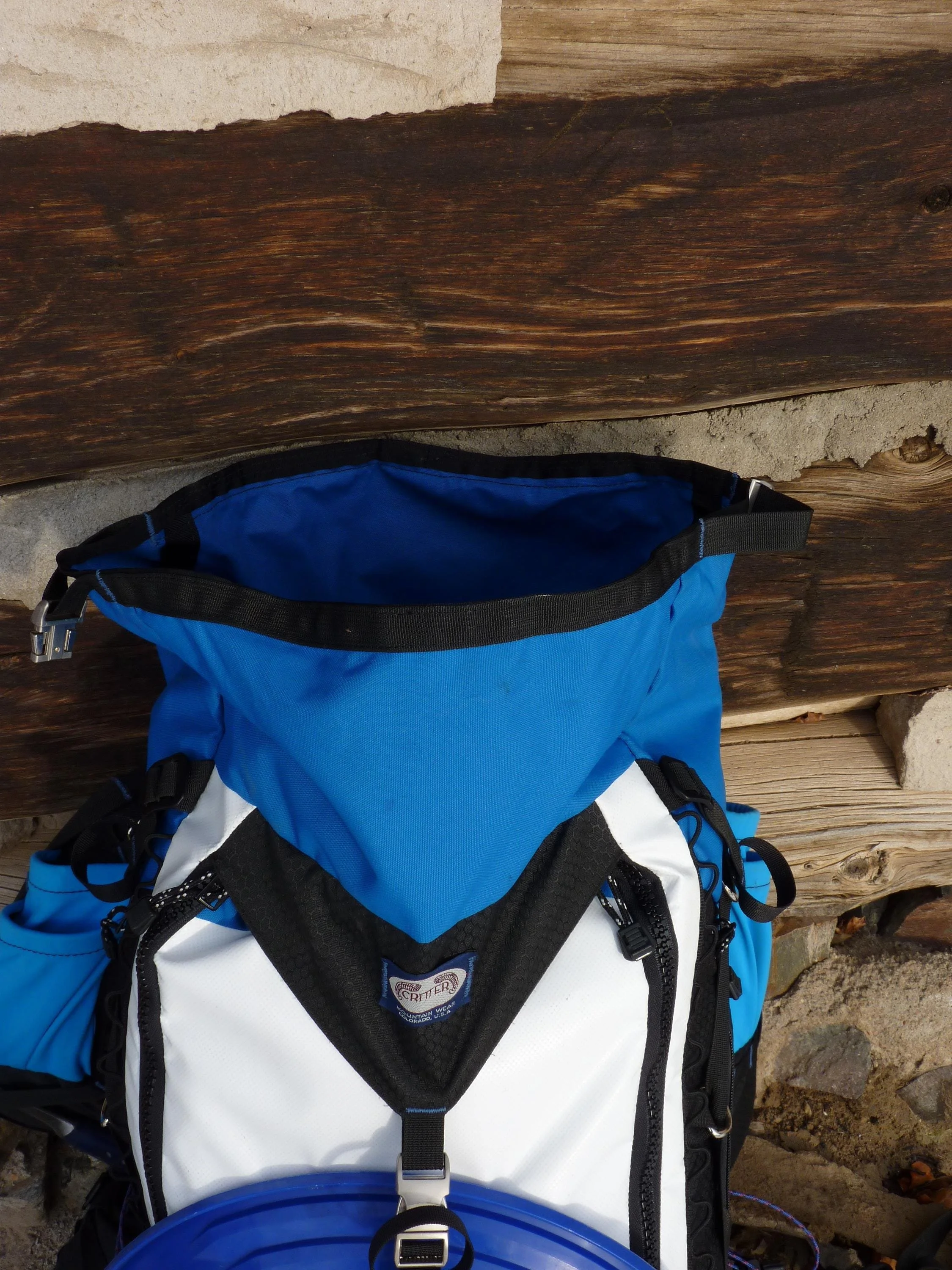 A blue and white backpack with a black zipper and a black strap. The backpack has a white logo that says 'Critter'.