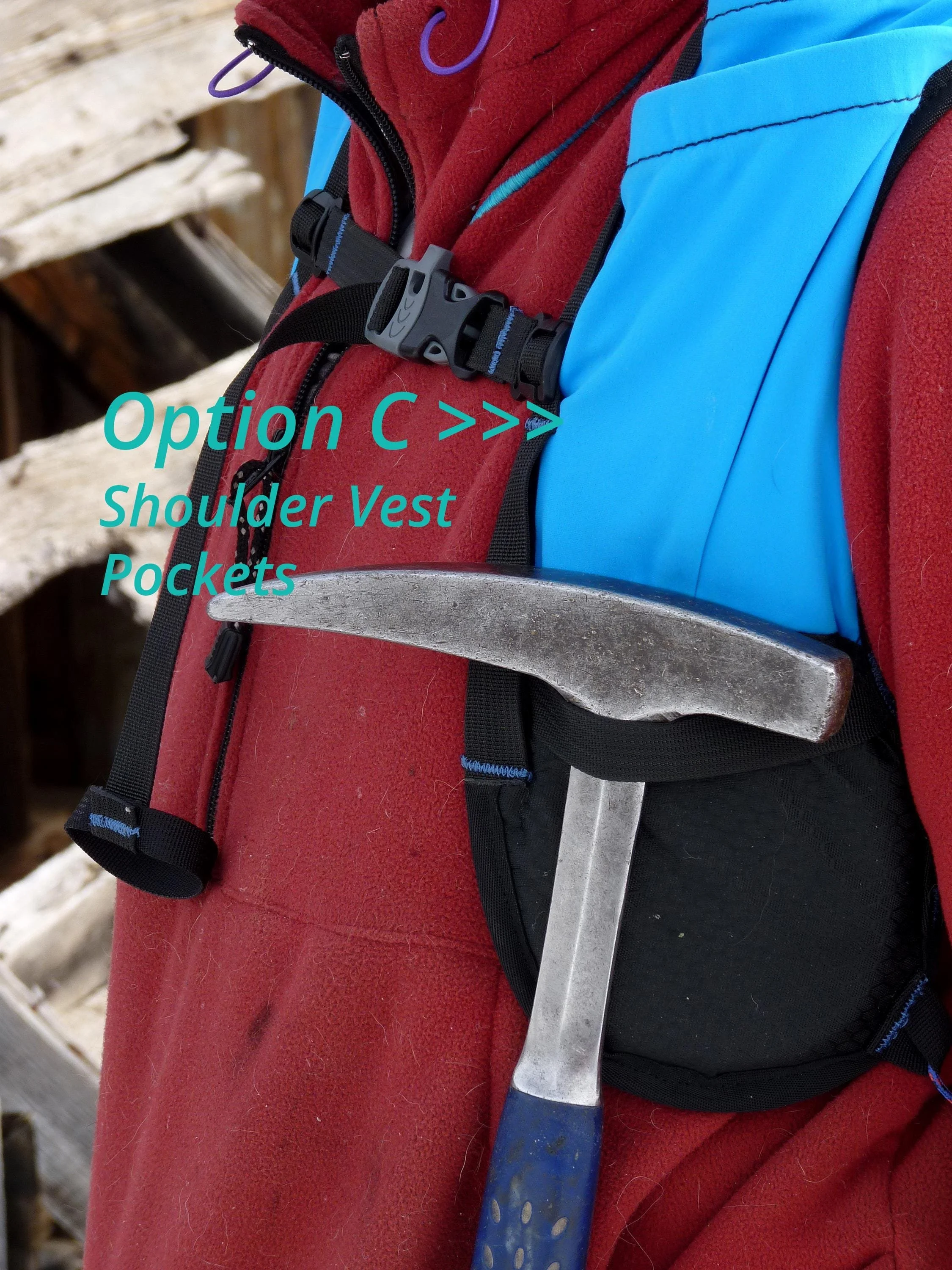 A black shoulder vest with a blue strap and a rock hammer in the pocket.